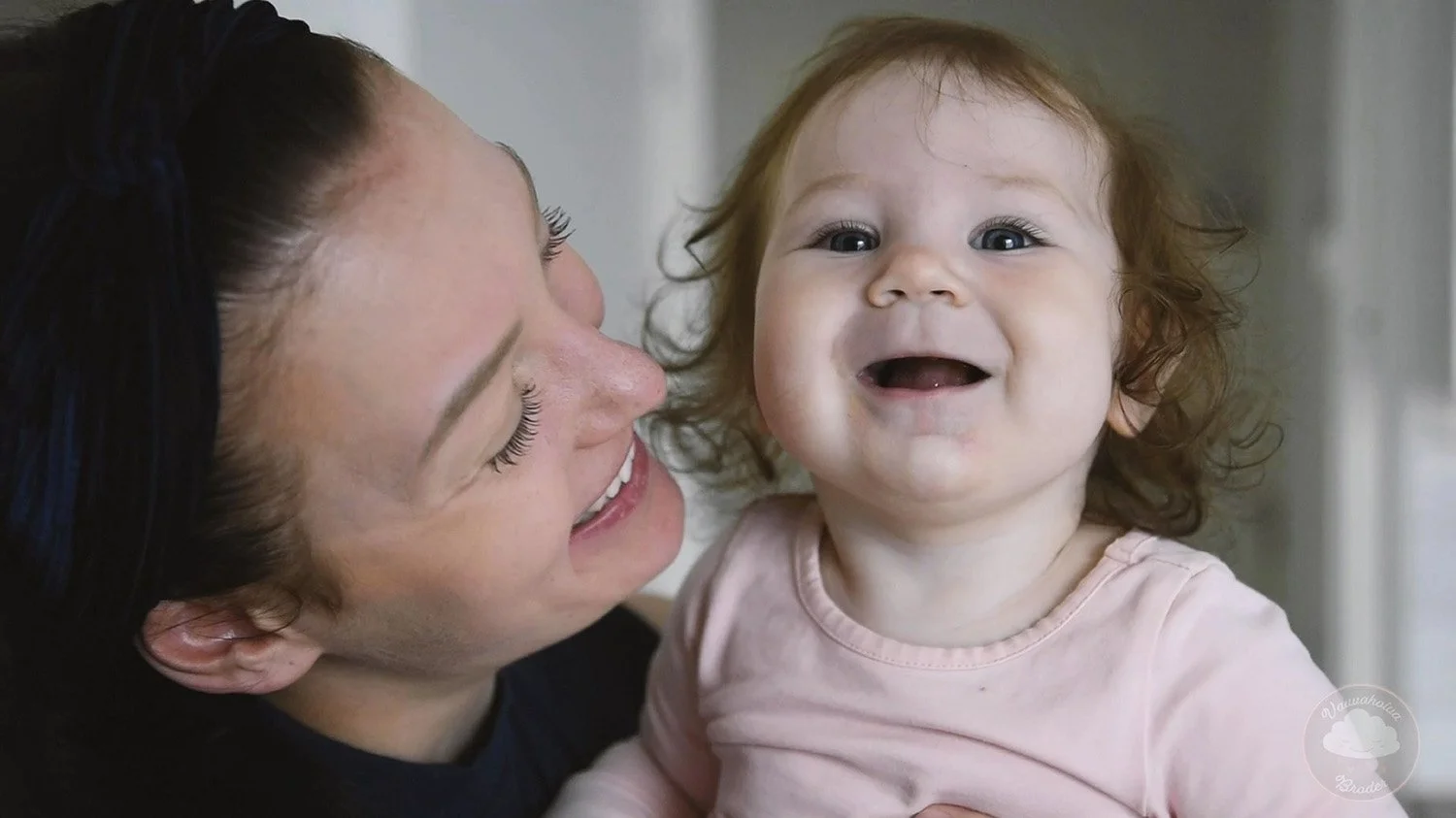 Nainen ja pieni lapsi hymyilevät ja katsovat toisiinsa lämpimästi.