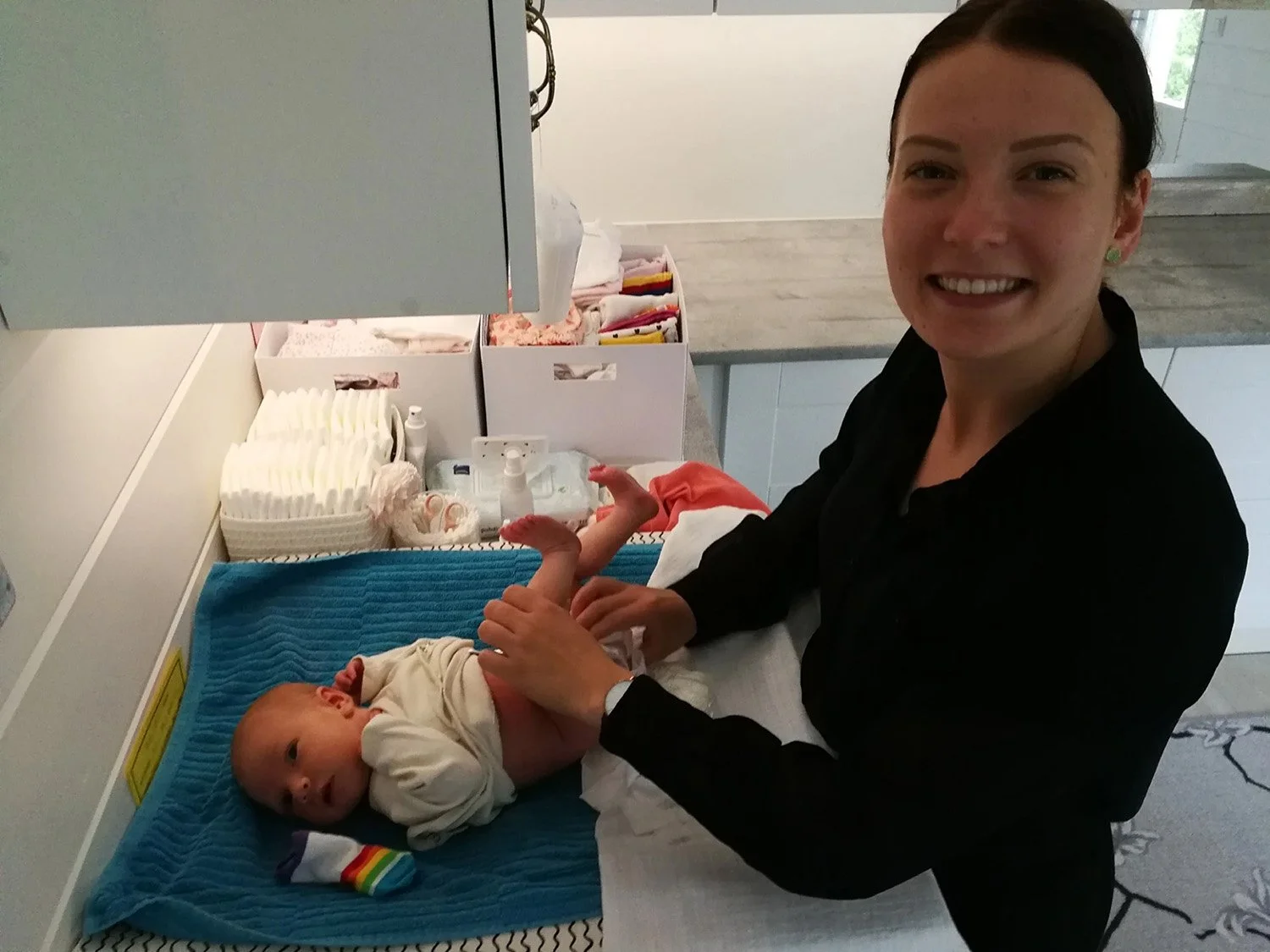 Nainen hoitaa vastasyntynyttä lasta sairaalassa tai neuvolassa.