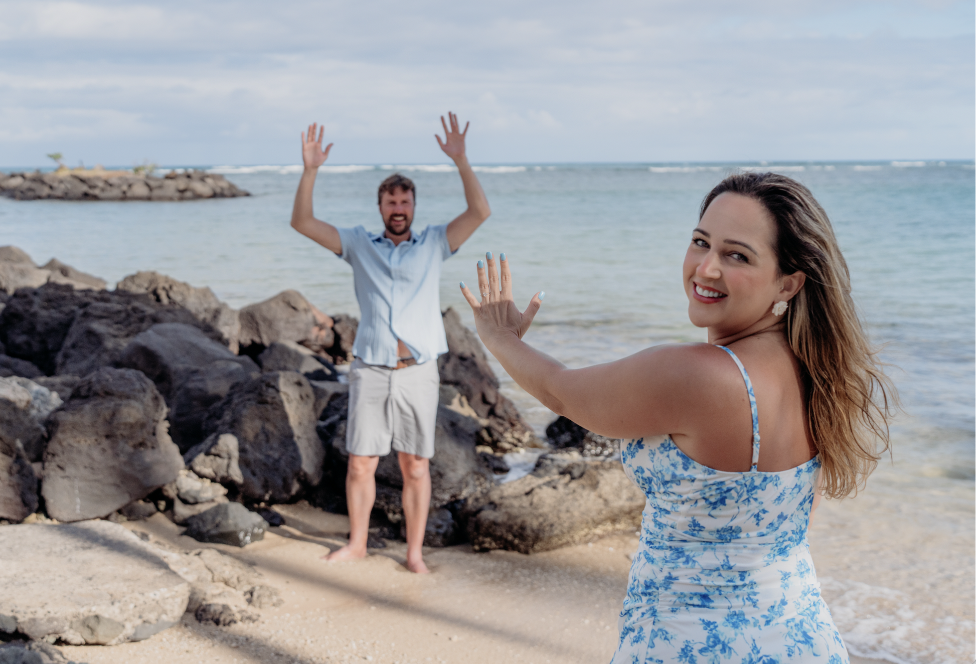 Playful couple posing on the beach during a candid photoshoot-fun idea for engagement or couple session by Natalya Vladi.