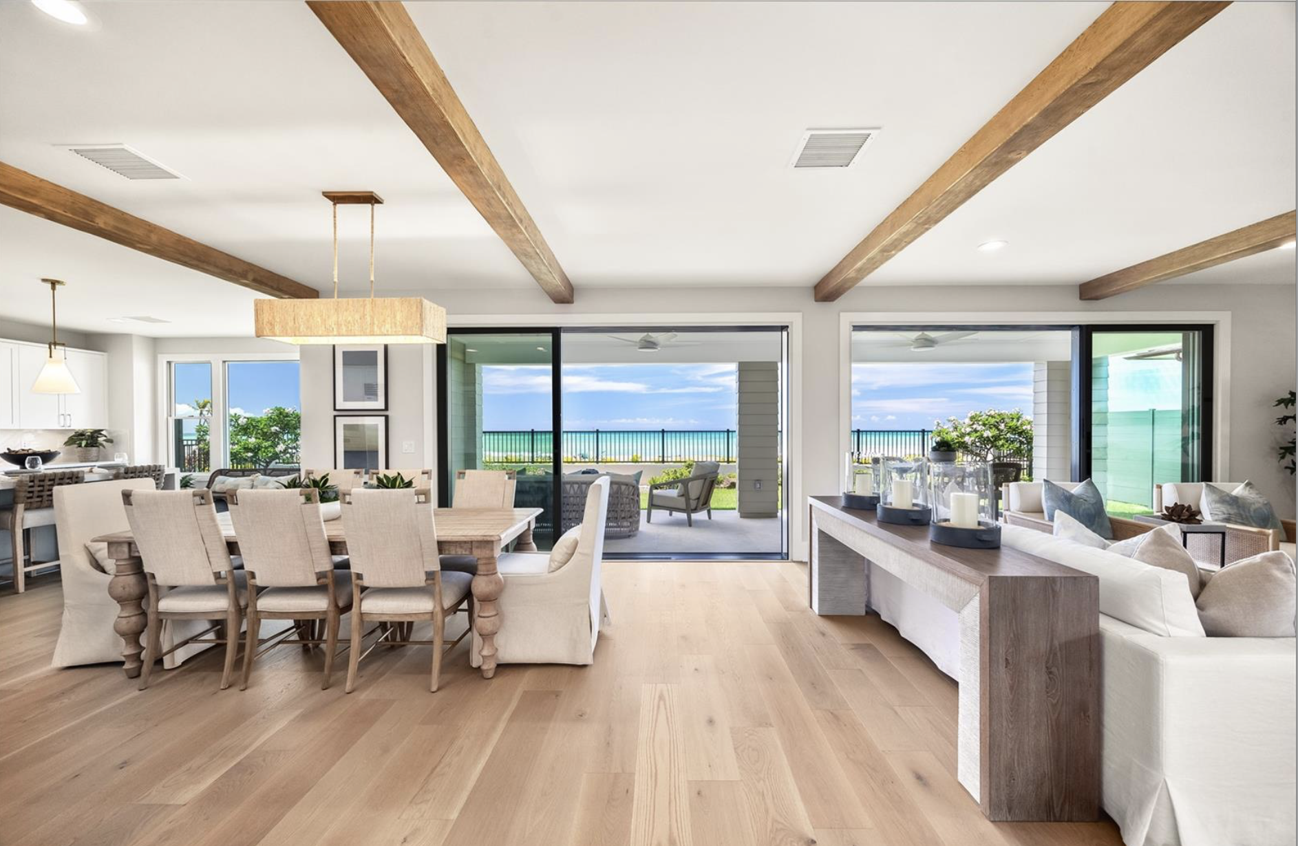 Living and dining area with large sliding glass doors leading to a patio with ocean view, luxury real estate photography for Dubai, Russia, and the USA. High-end interior imagingand premium architectural detail. Perfect for developers, agents,