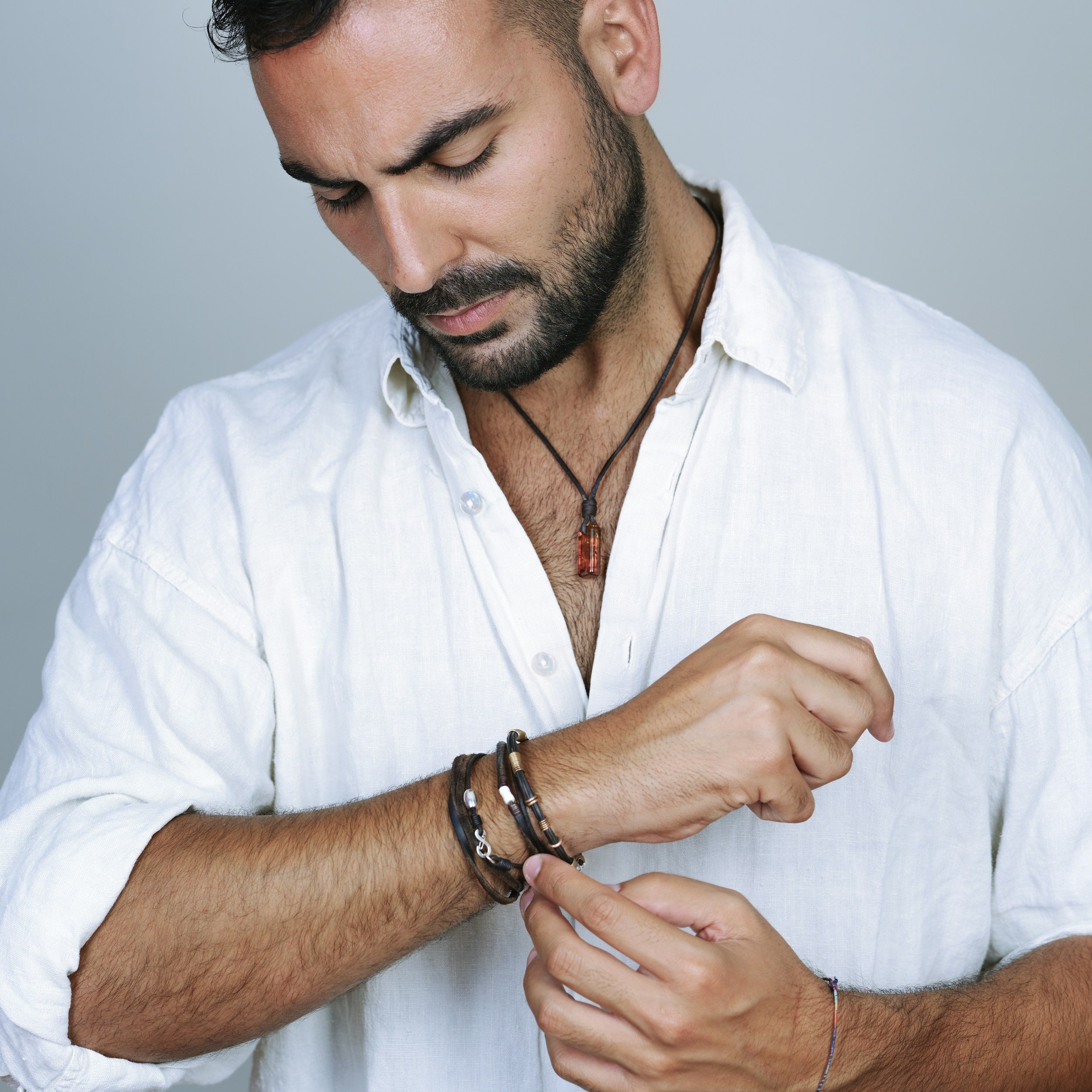 Close-up of a man adjusting his shirt and accessories during a branding photoshoot