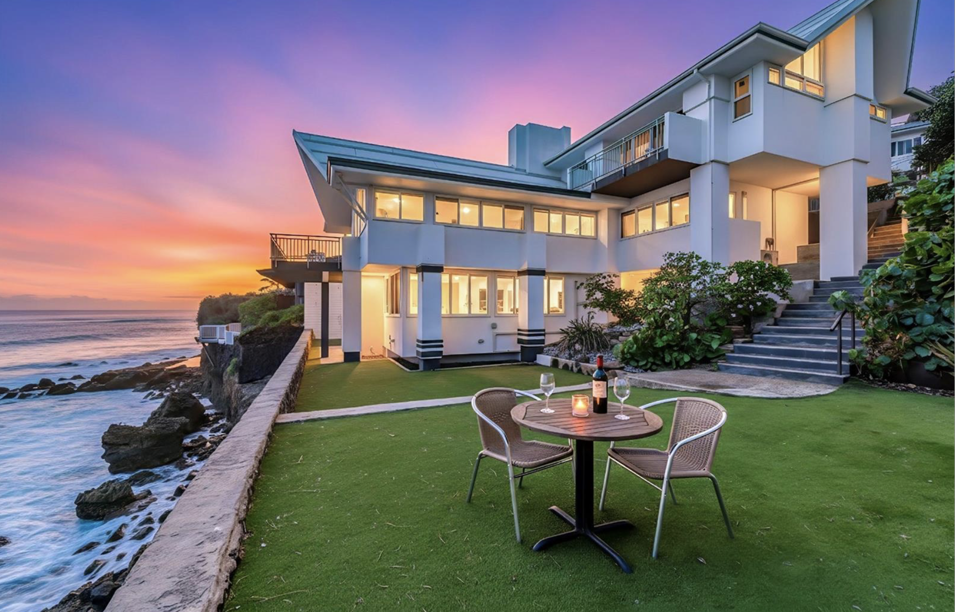 Modern beachfront house during sunset with outdoor patio, table, and glasses of wine.International luxury real estate photography for Dubai, Russia, and the USA. and premium architectural detail. Perfect for developers, agents, and designers.