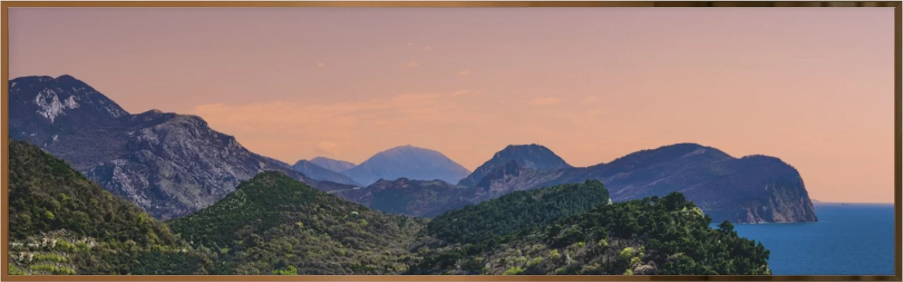 Panoramic mountain landscape at sunset with rolling hills, dramatic peaks, and tranquil blue waters, fine art photography wall art print.