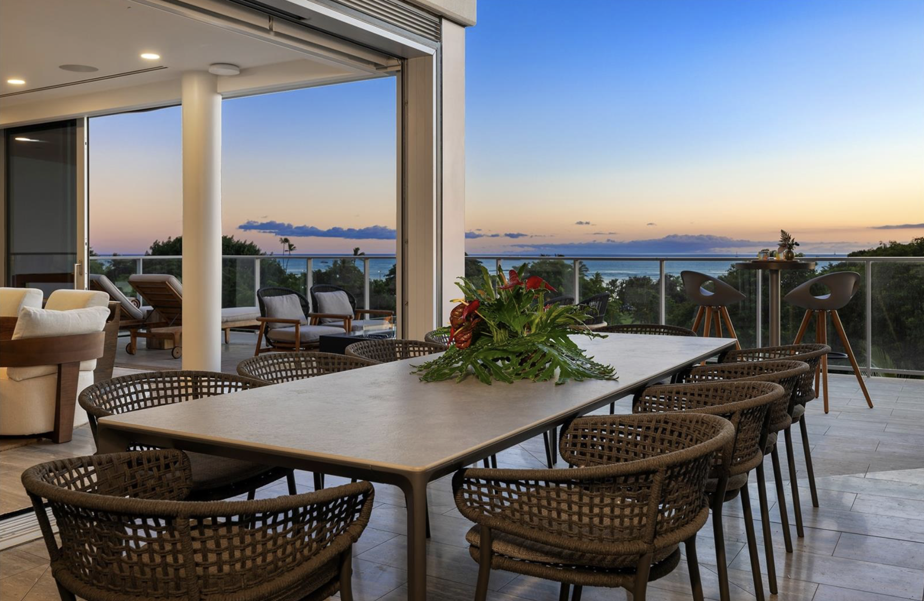 Luxury outdoor patio with dining area, tropical plants, ocean view at sunset,luxury real estate photography for Dubai, Russia, and the USA. High-end interior imagingand premium architectural detail. Perfect for developers, agents, and designers.