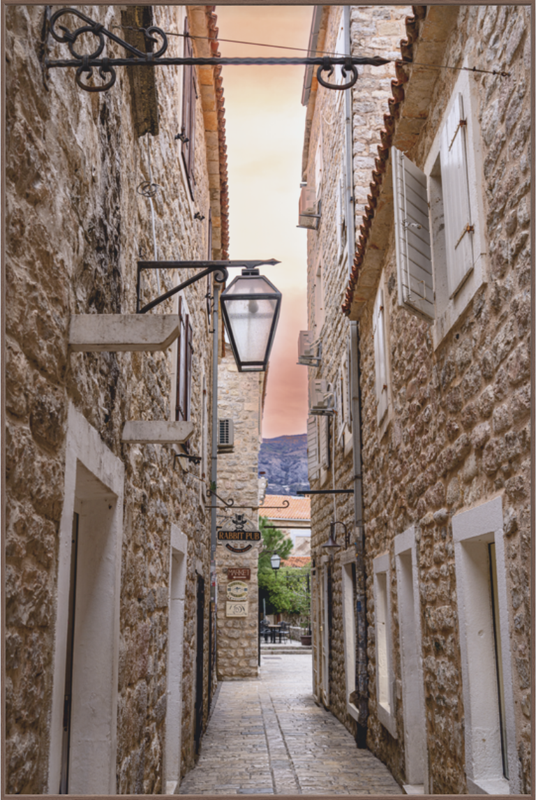 Historic Mediterranean stone alleyway with rustic architecture, iron lanterns, and warm sunset light, fine art travel photography wall art print.