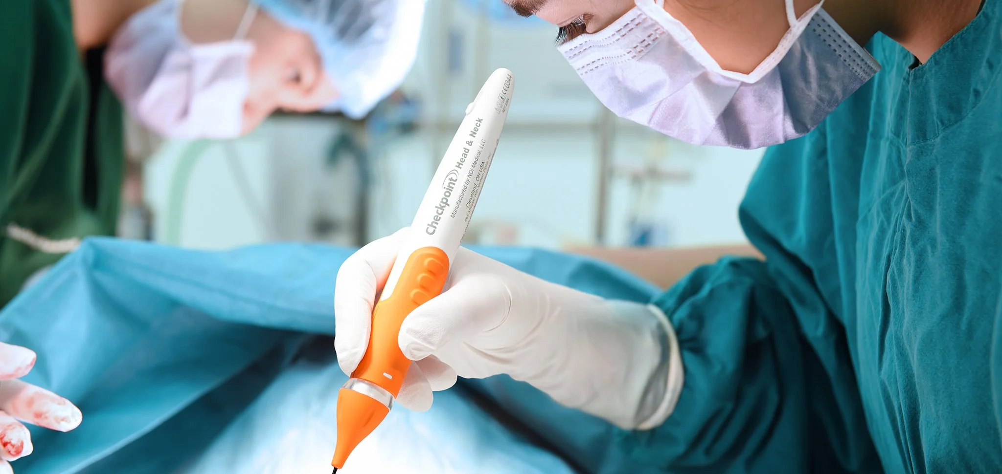 Surgeon holding a nerve stimulator device while in surgery