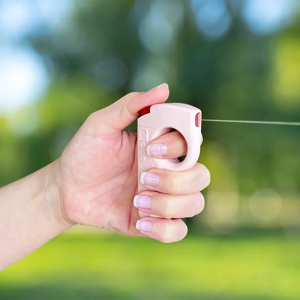 Female hand holding and using Mace PocketHero pepper spray