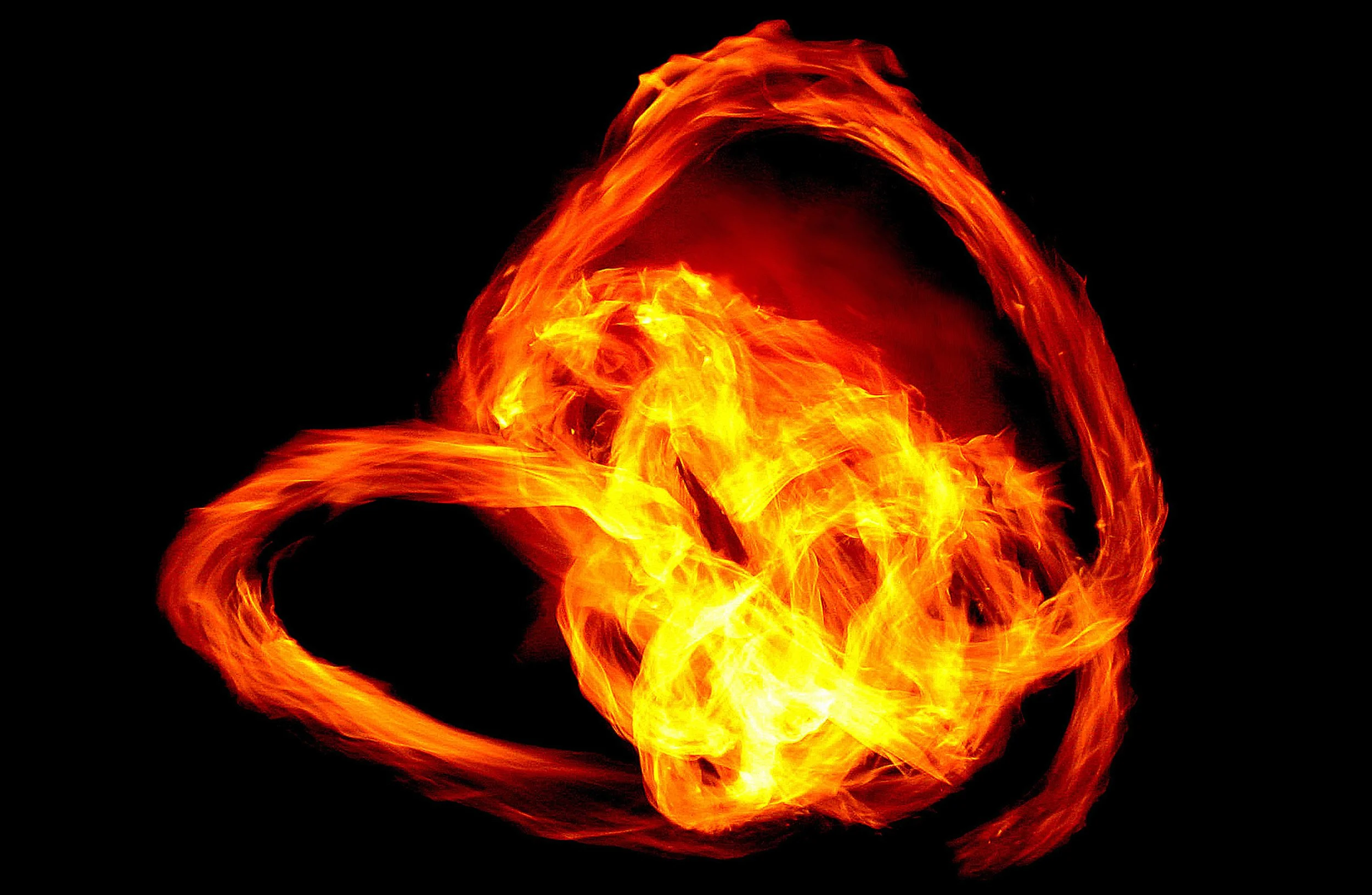 Ljusa och röda eldsflammor som snurrar runt framför en svart bakgrund. 