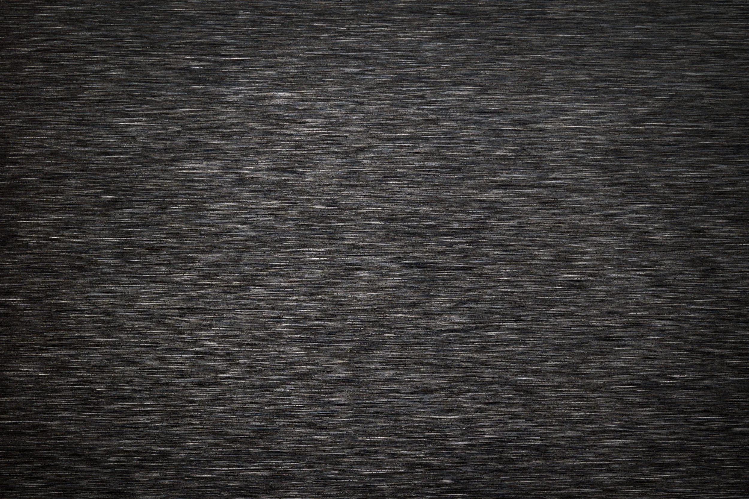 A dark, textured wooden surface with visible grain and horizontal lines.
