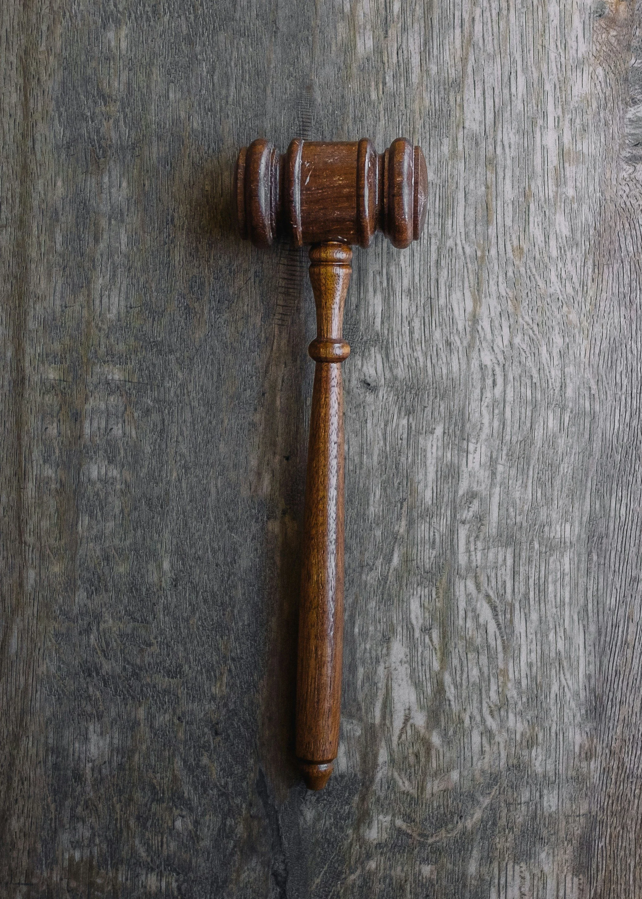 Wooden gavel placed on a wooden surface.