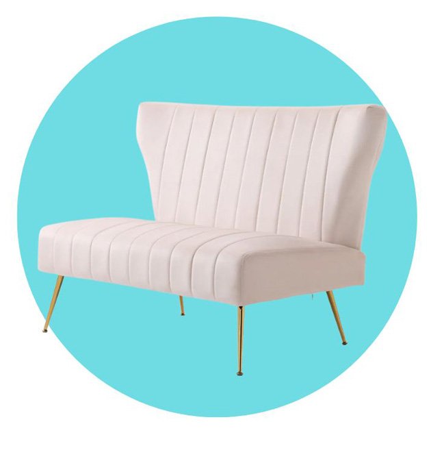 A pale pink velvet loveseat with gold metal legs set against a blue circular background.