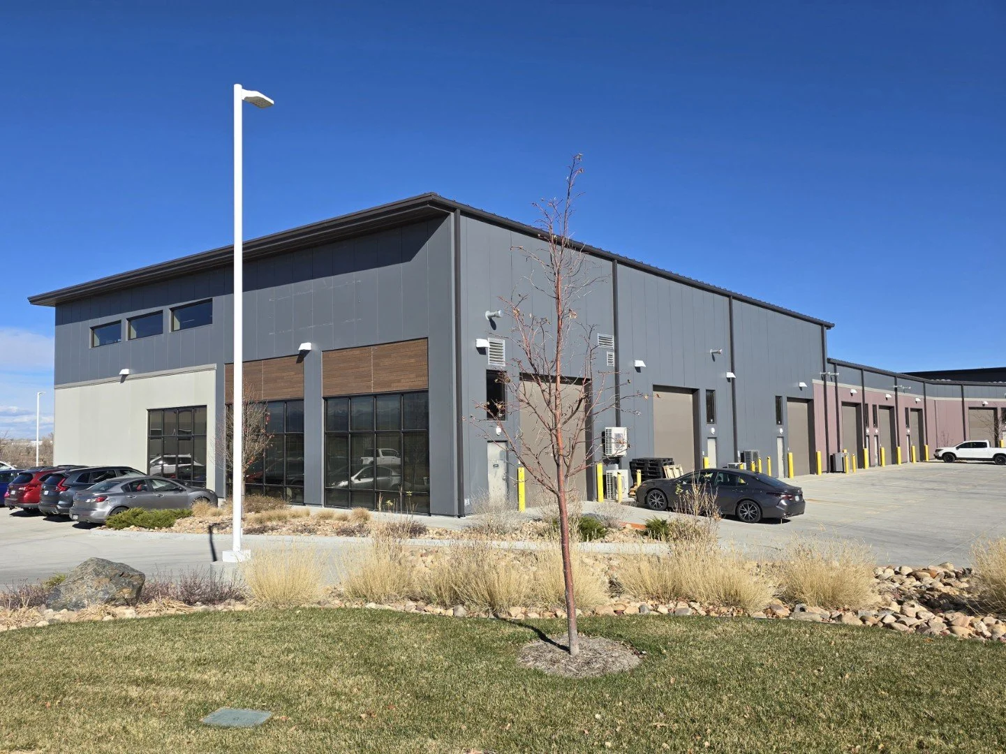 West rear elevation of Own It Vista flex office warehouse condos in Lafayette Colorado showing drive-in overhead doors and warehouse access.