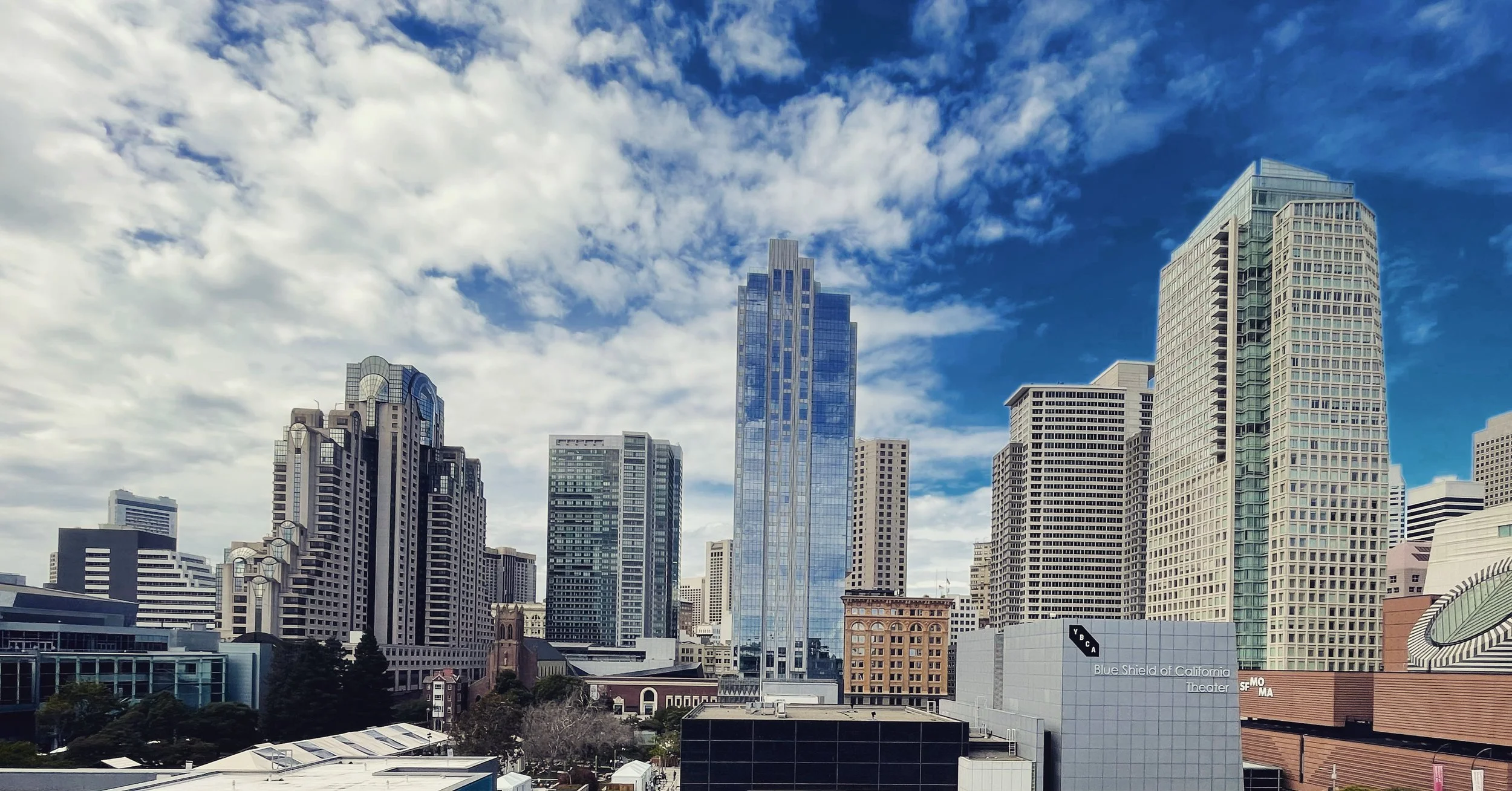 San Francisco skyline with tall skyscrapers under a partly cloudy sky.