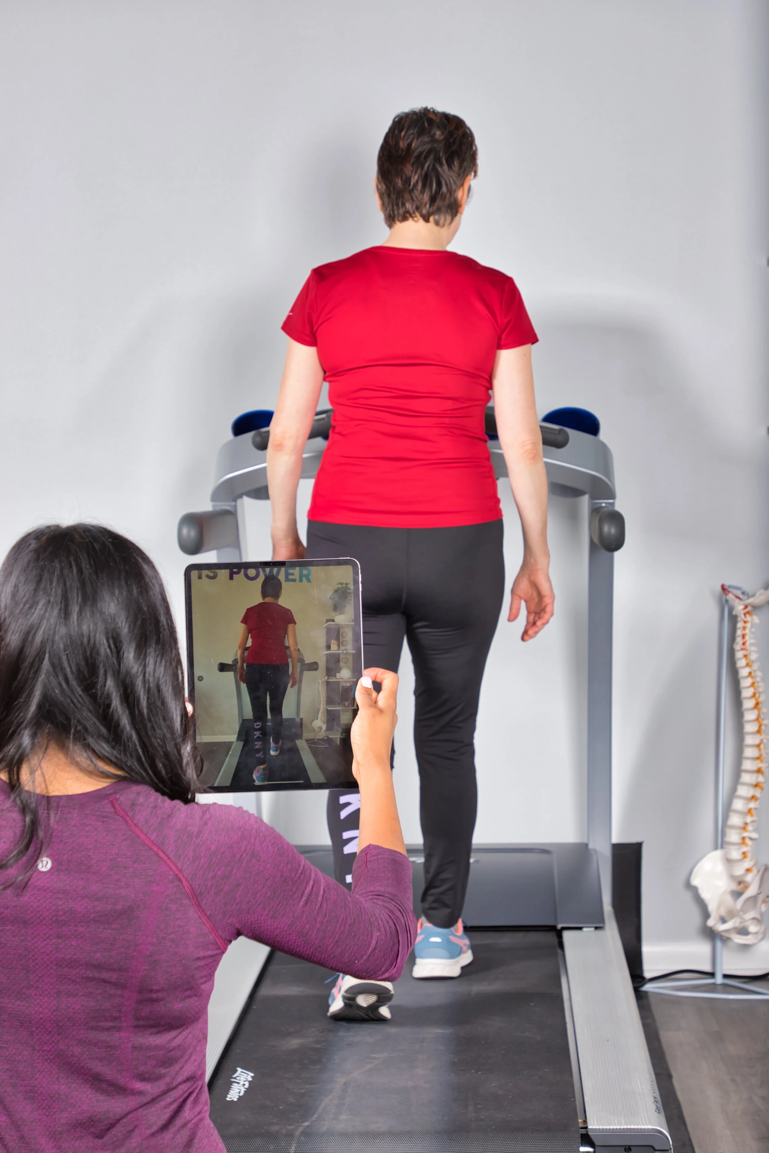 A woman walking on a treadmill during a gait analysis exam.