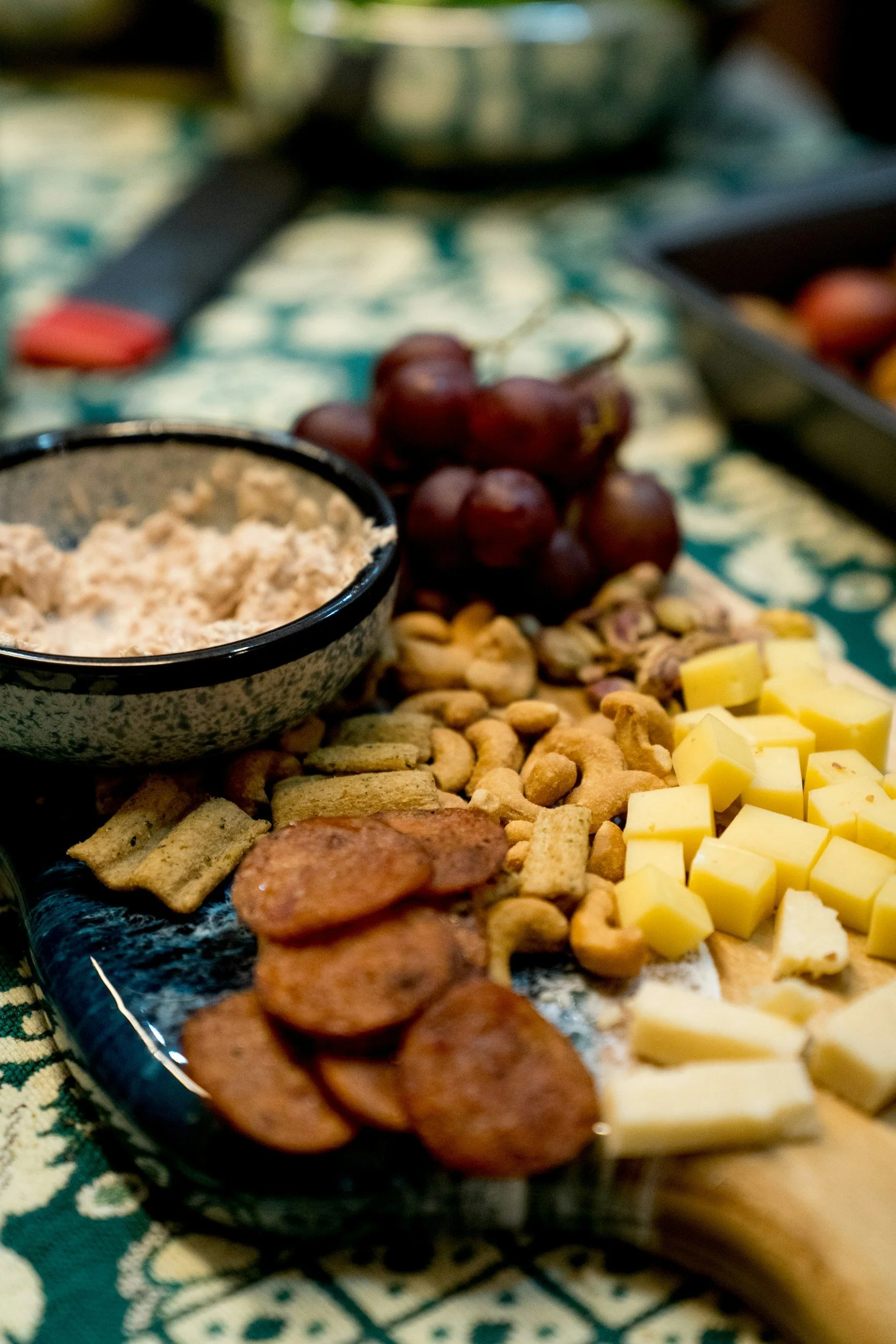 Cheese, crackers, grapes, nuts, and a bowl of dip on a serving platter from The Charcuterie Chics near Charlotte NC
