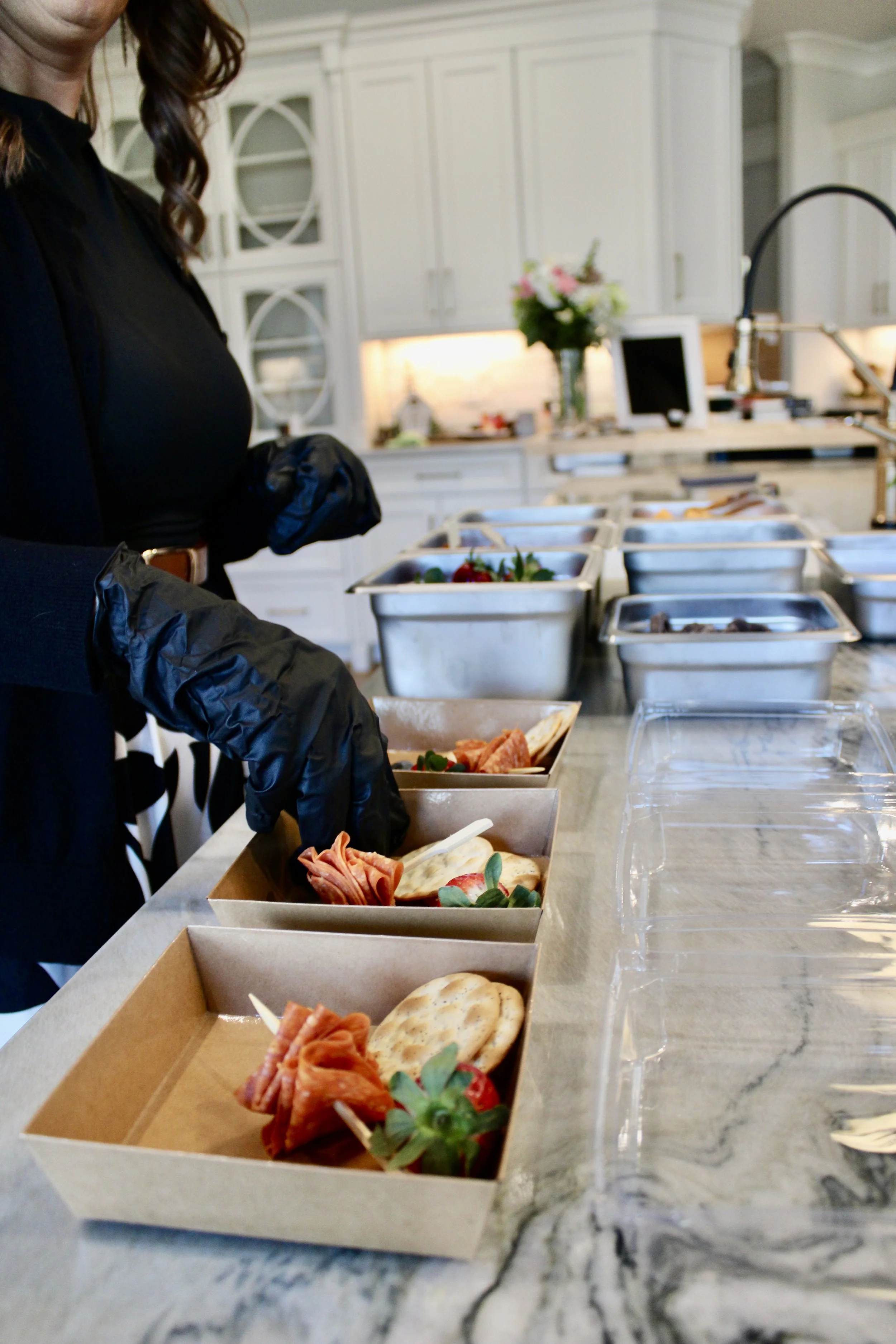 Amber wearing black gloves preparing to-go charcuterie boxes for a wedding event The Charcuterie Chics near Hickory NC
