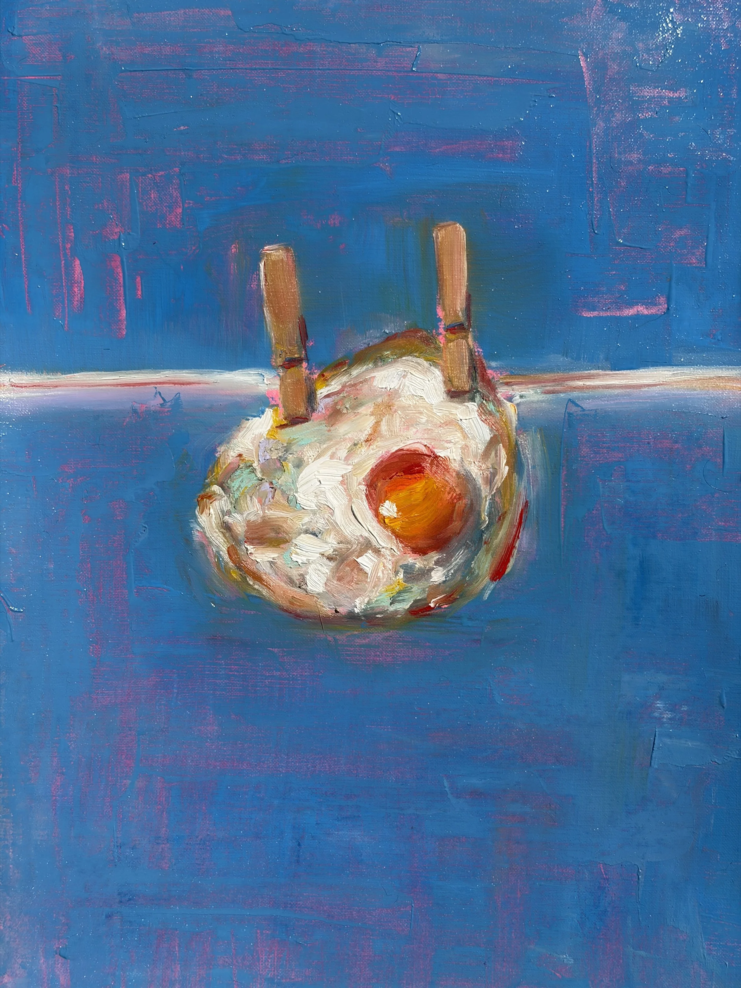 A painting of a fried egg hanging on a close line by close-pins.