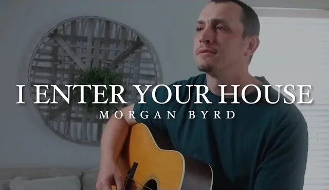 A man holding a guitar, with a decorative wall feature behind him, and the text "I ENTER YOUR HOUSE" by Morgan Byrd overlaid on the image.