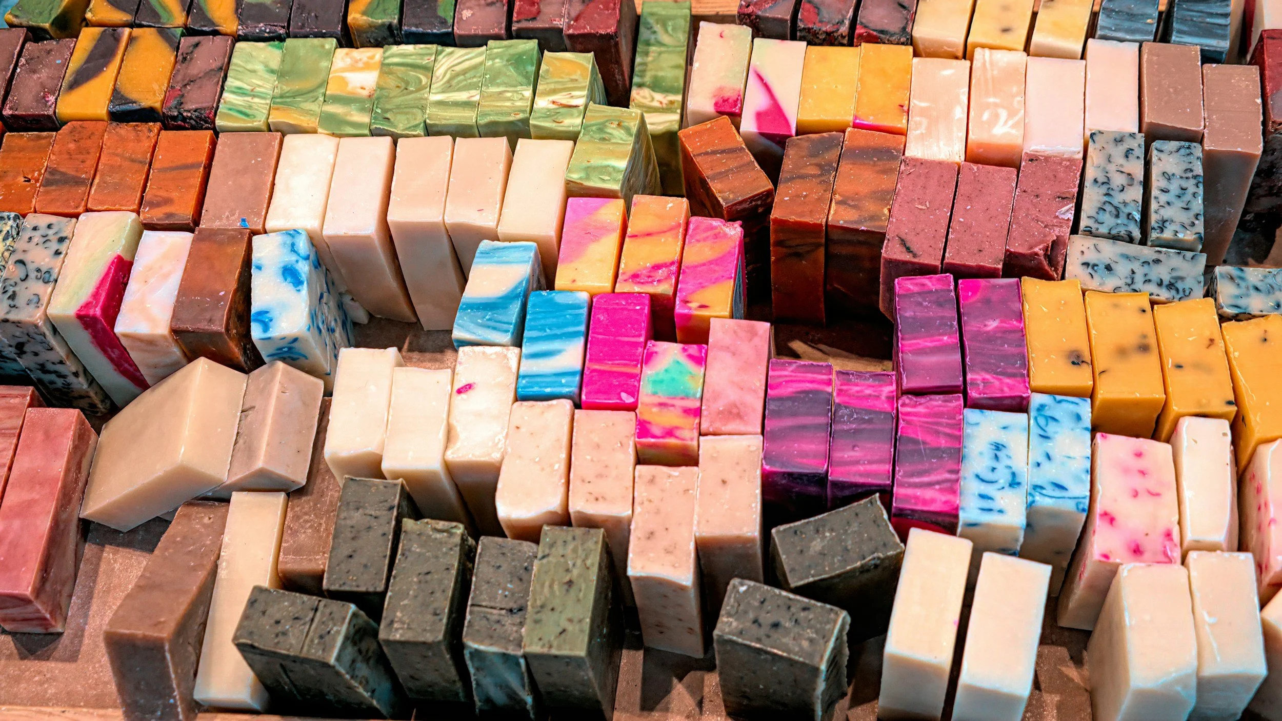 Assorted colorful soap bars arranged on a display table.