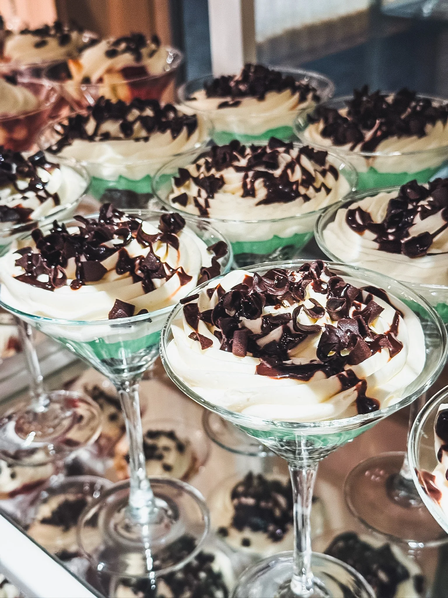 Dessert cups filled with whipped cream, topped with chocolate shavings or chocolate chips.