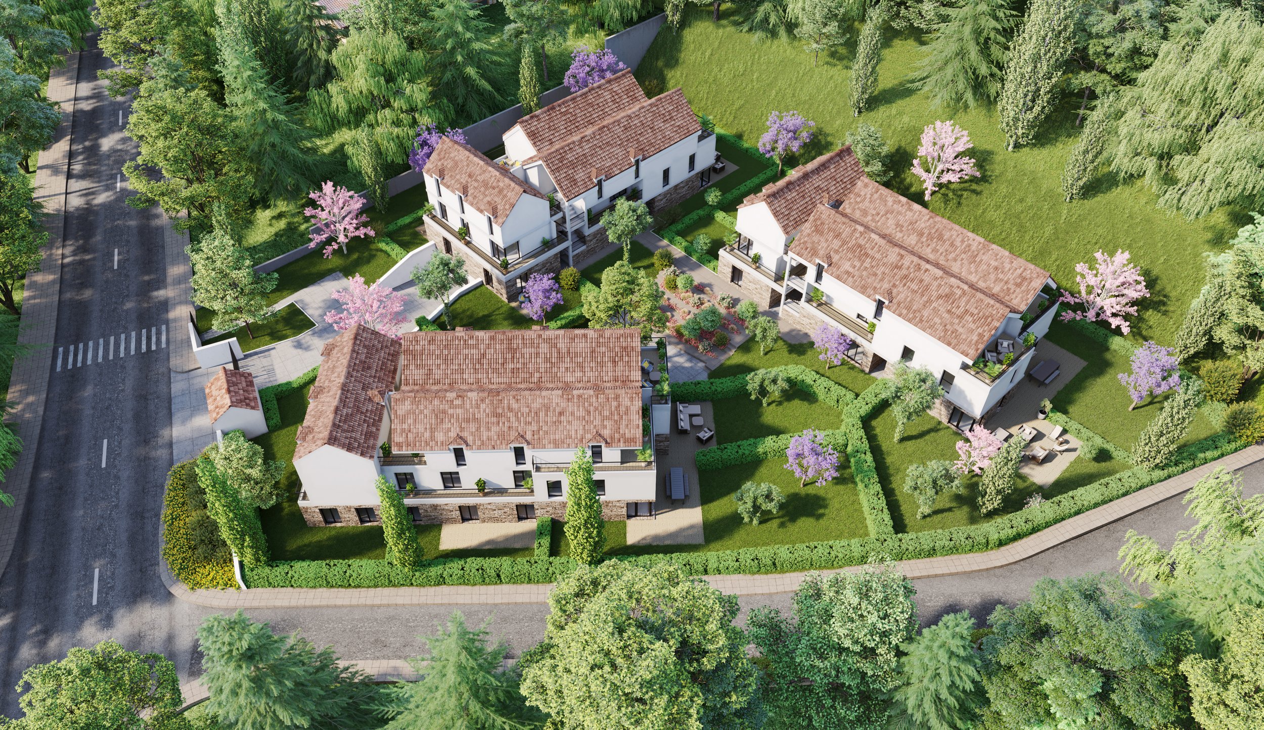 Vue aérienne Domaine Les Arômes | Vue aérienne d'un complexe résidentiel avec plusieurs maisons, jardins et arbres en fleurs, entouré d'une clôture et accessible par une route.