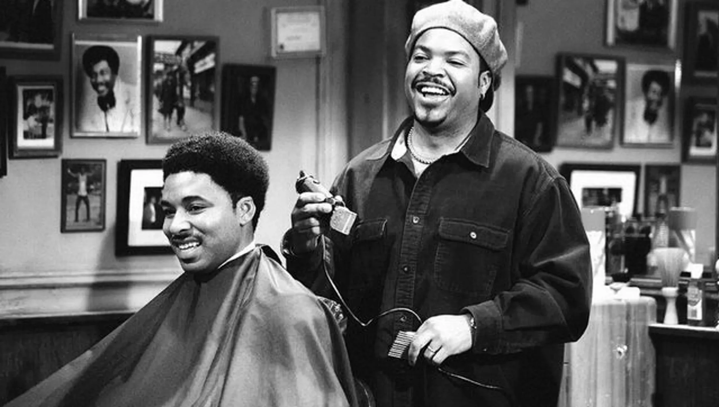 Un homme est en train de couper les cheveux d’un client dans un salon de coiffure.