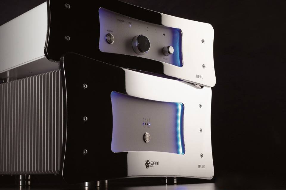 Due apparecchiature elettroniche, uno nero e uno bianco con luci blu, posizionati uno sopra l'altro su un piano nero.