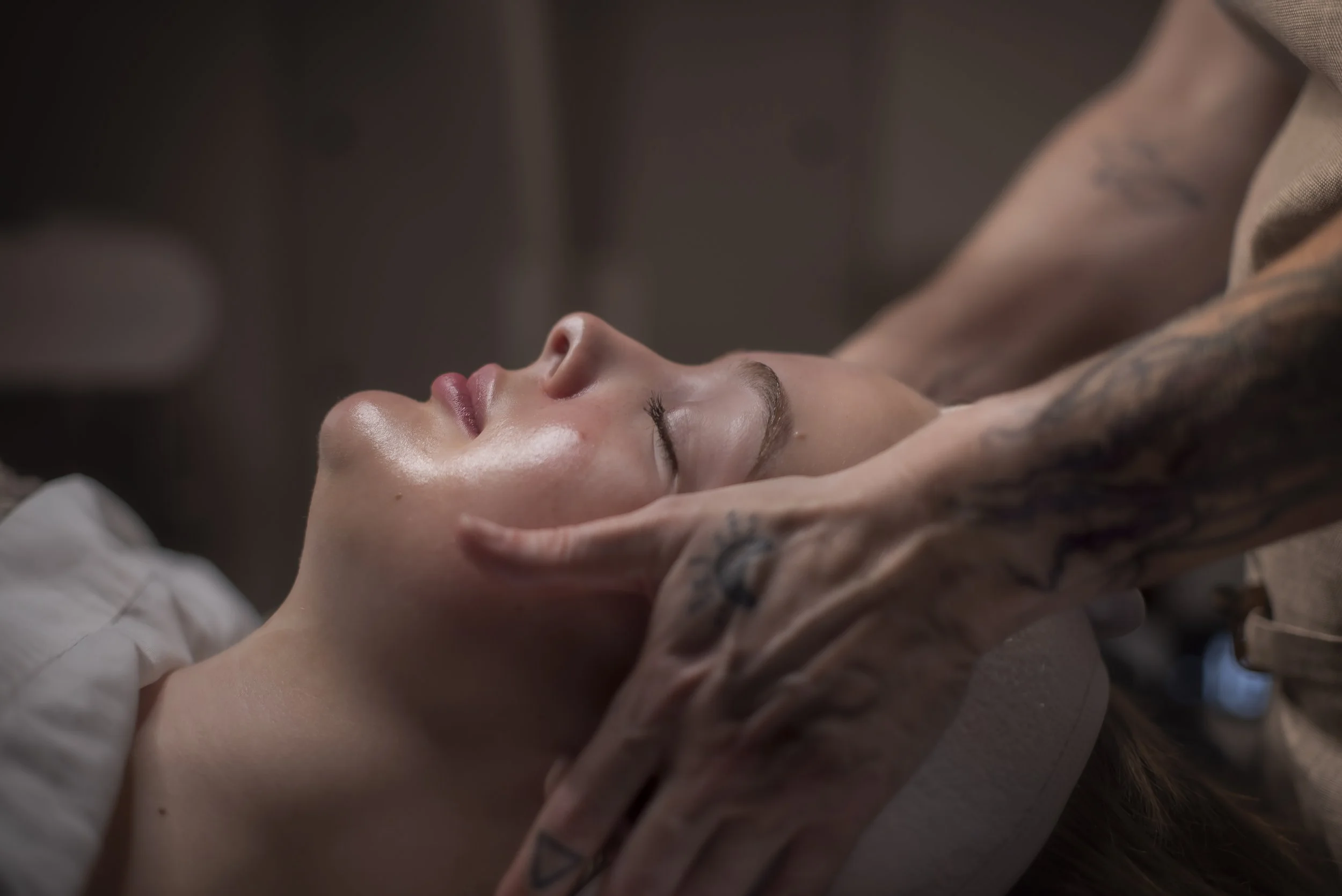 Person receiving a facial massage with closed eyes.
