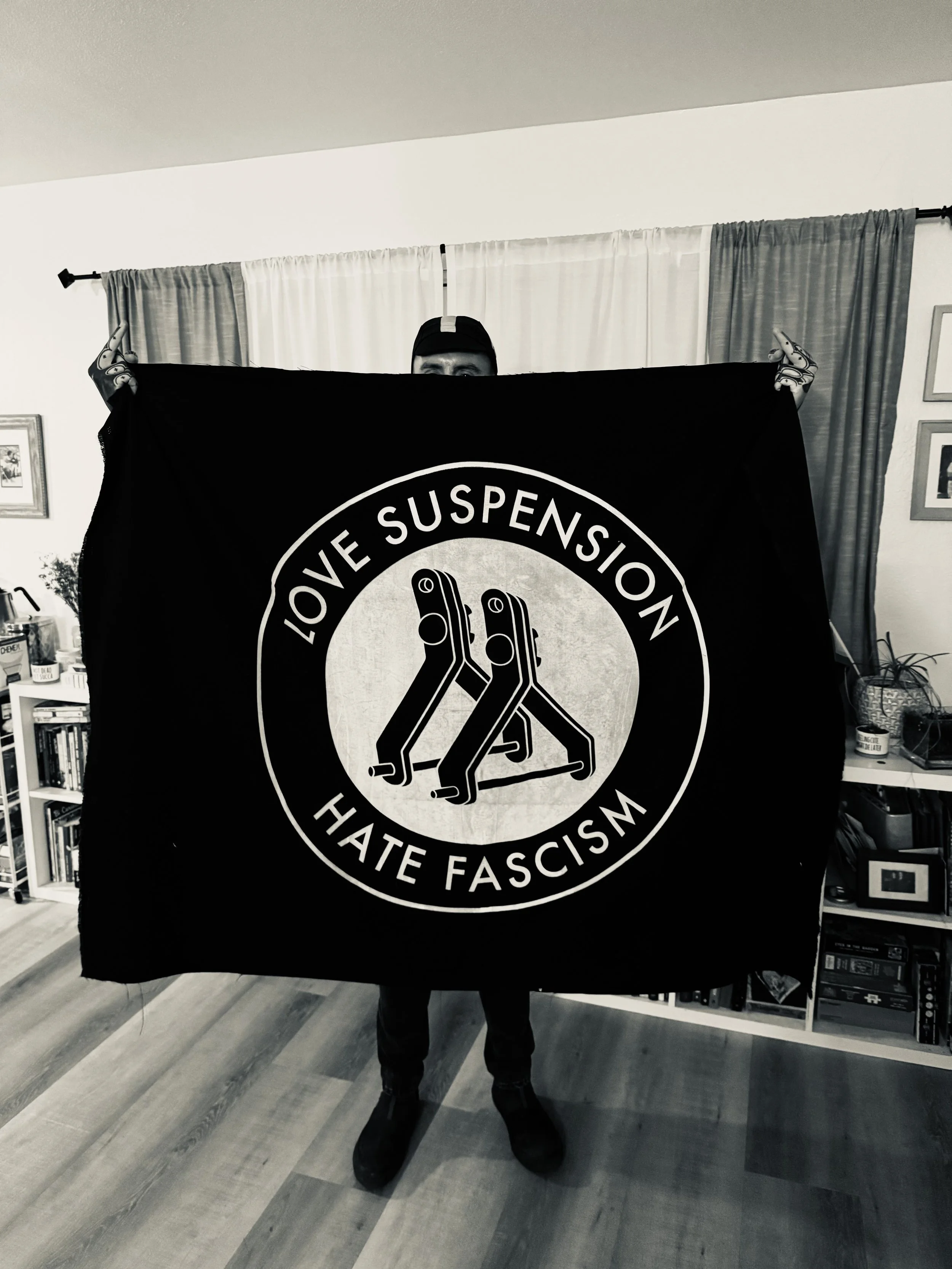 My friend Jesse holding up a giant version of the Love Suspension, Hate Fascism emblem that I screenprinted on canvas