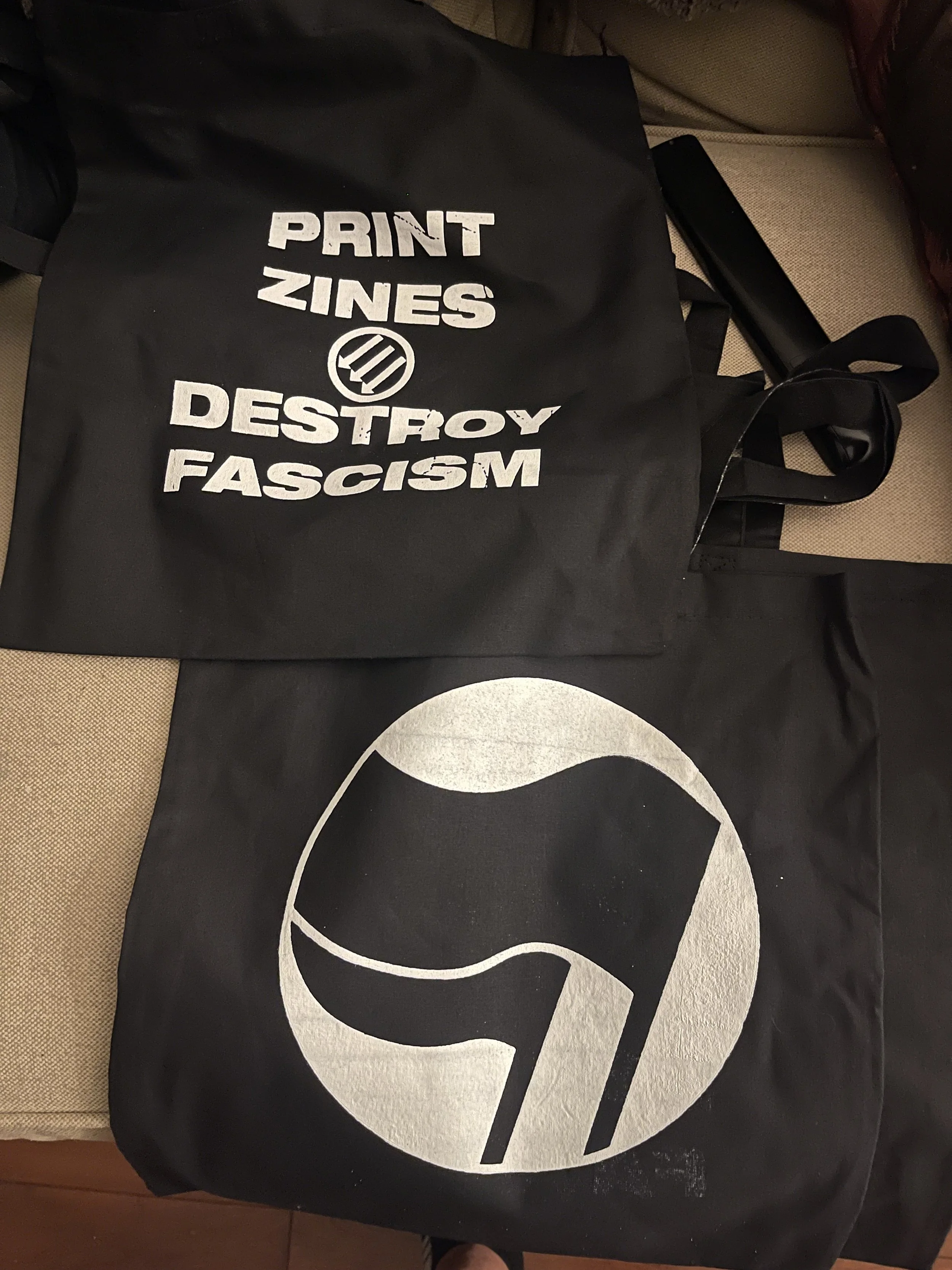 The "Print Zines, Destroy Fascism" totes were printed for the Hamilton Anarchist Bookfair