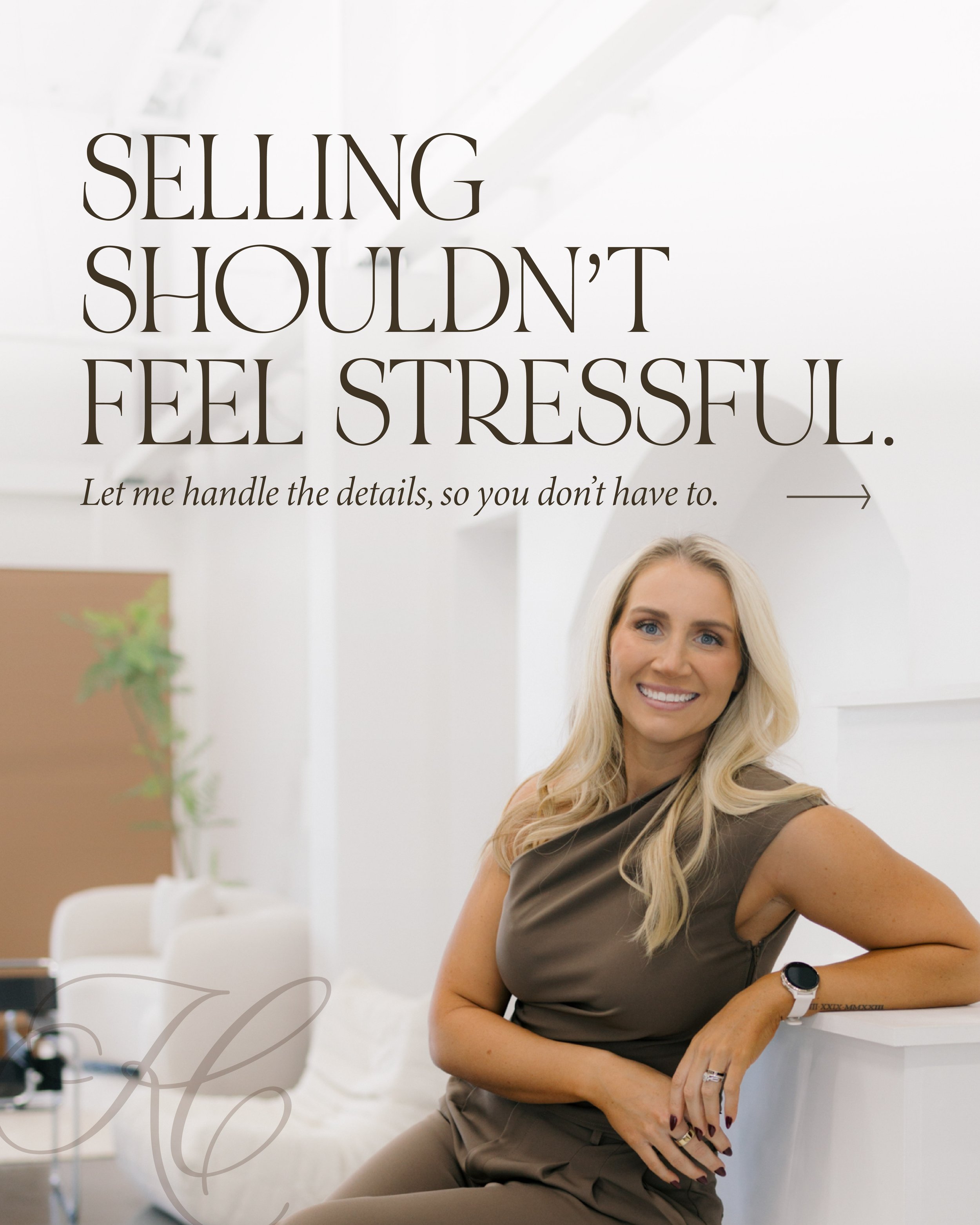 A woman with long blonde hair and blue eyes smiling, wearing a brown sleeveless top and a smartwatch on her left wrist, sitting at a white desk in a modern, well-lit room with white walls. A partial view of a potted plant and some decorative furniture are visible in the background.