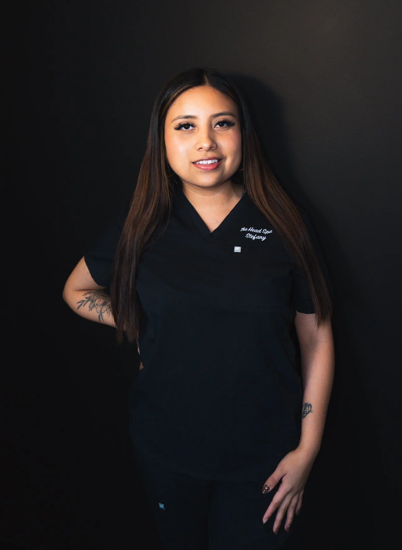 Interior of a pink-themed coffee shop with a round table, two chairs, a pink tufted bench, pink curtains, a menu board, and a counter with coffee equipment and decorative items.