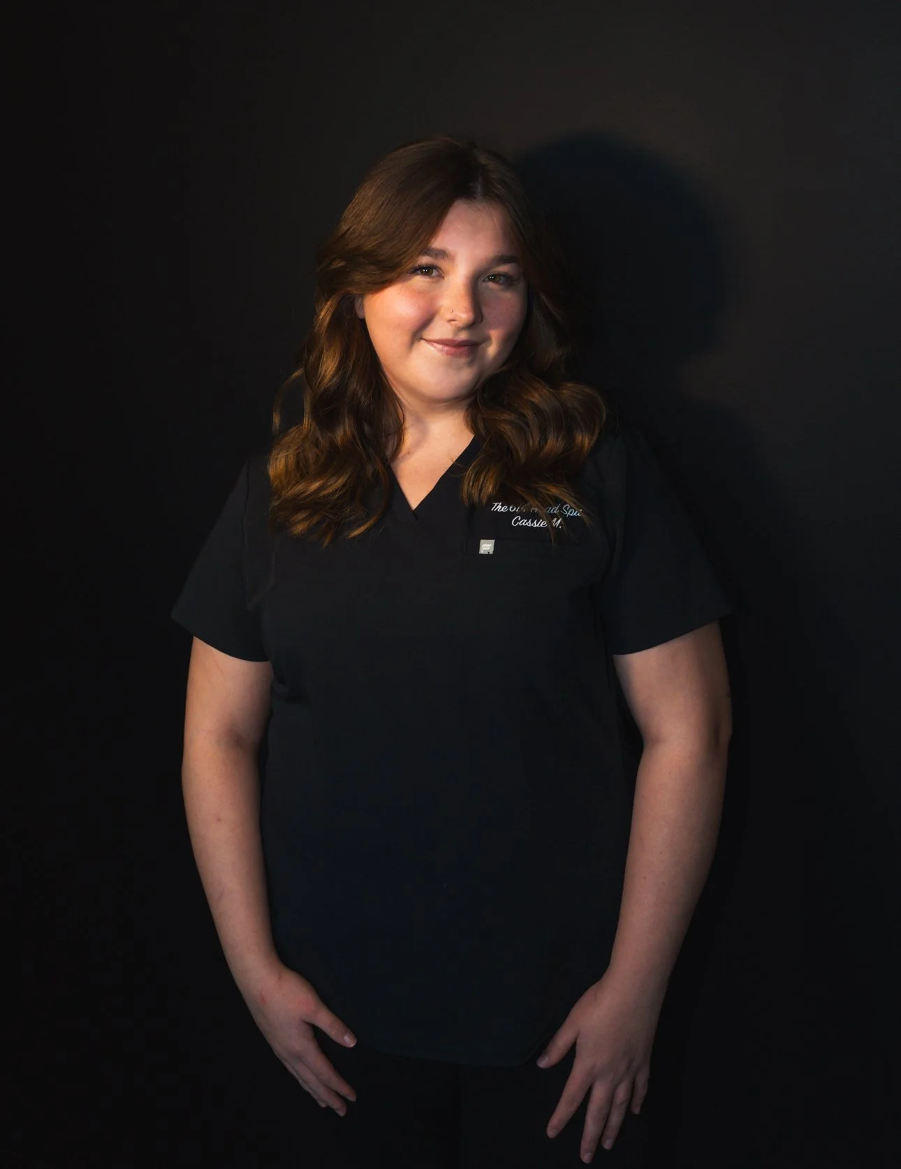 Close-up of a textured glass filled with water, creating intricate light patterns and shadows on the white surface below.