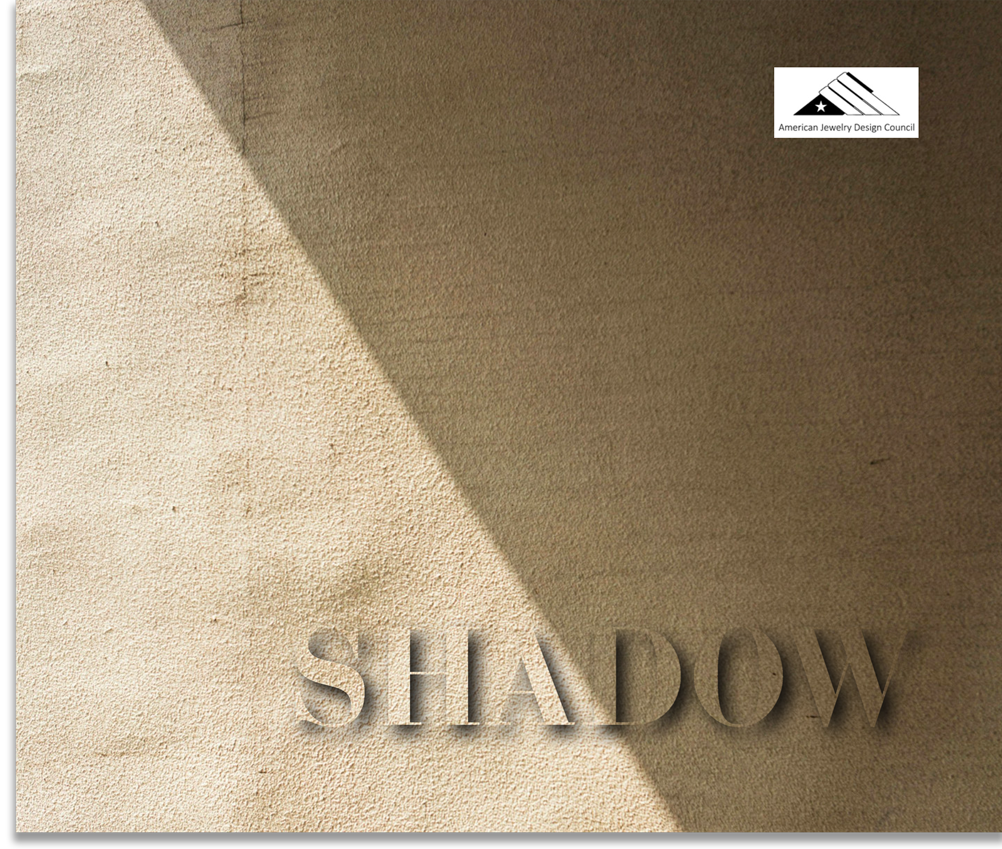 Close-up of a beige textured surface with the partial shadow of objects, and a logo of the American Jewelry Design Council in the upper right corner.