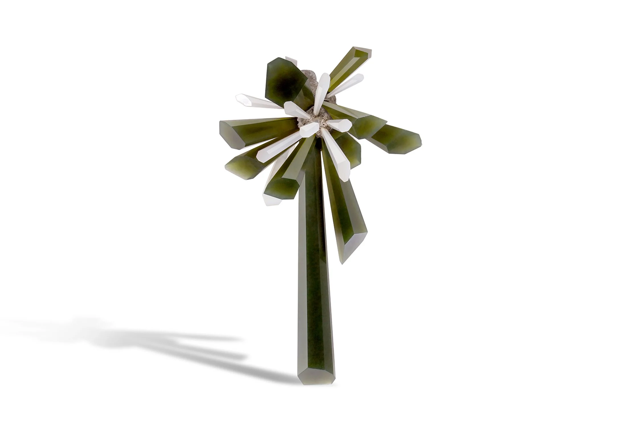 A decorative object resembling a star or snowflake, made of elongated green and white geometric pieces, casting a shadow on a white background.