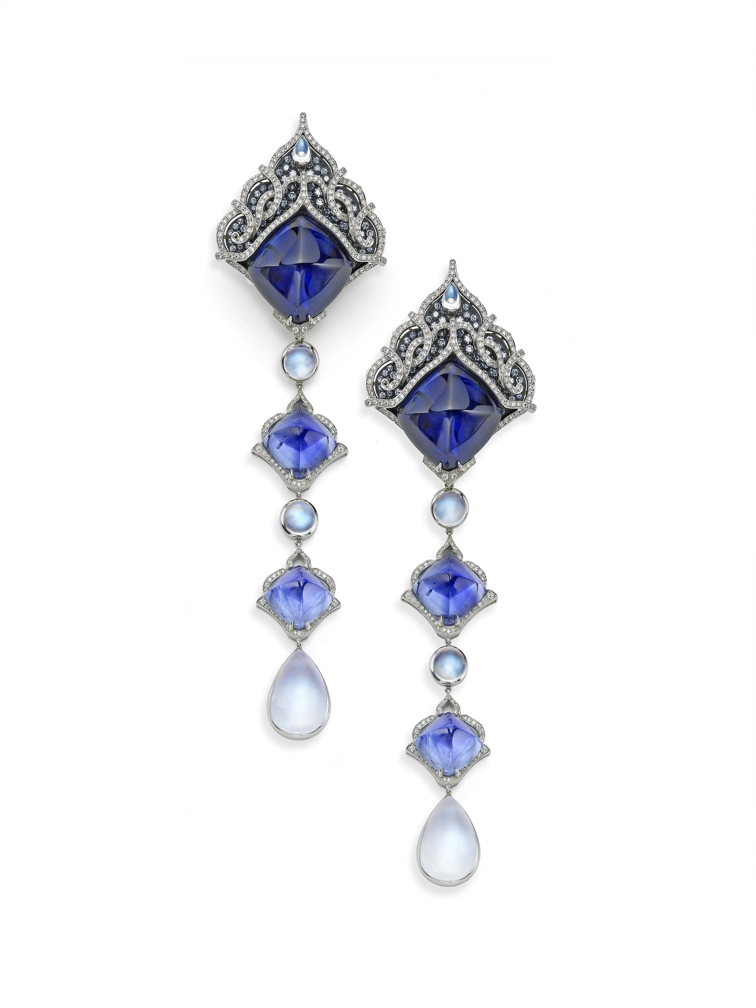 Elegant pair of earrings featuring large blue gemstones, surrounded by intricate silver designs and adorned with smaller pearls and diamonds.