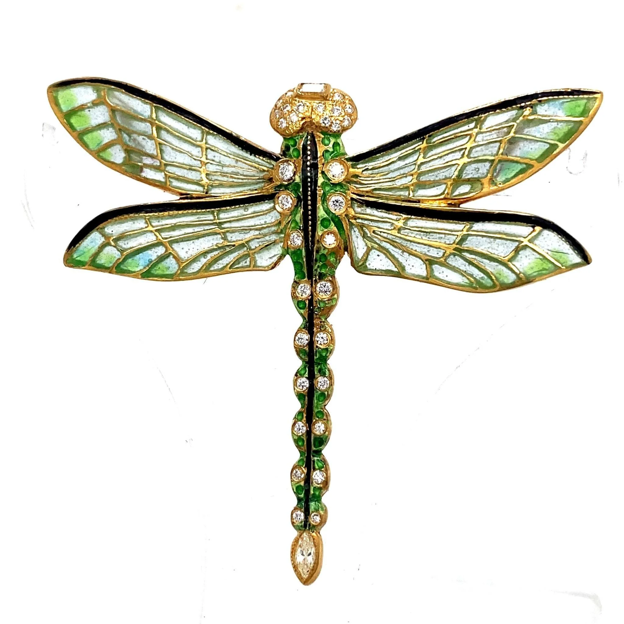 A decorative dragonfly brooch with gold, green and clear rhinestones, and stained glass-like wings.