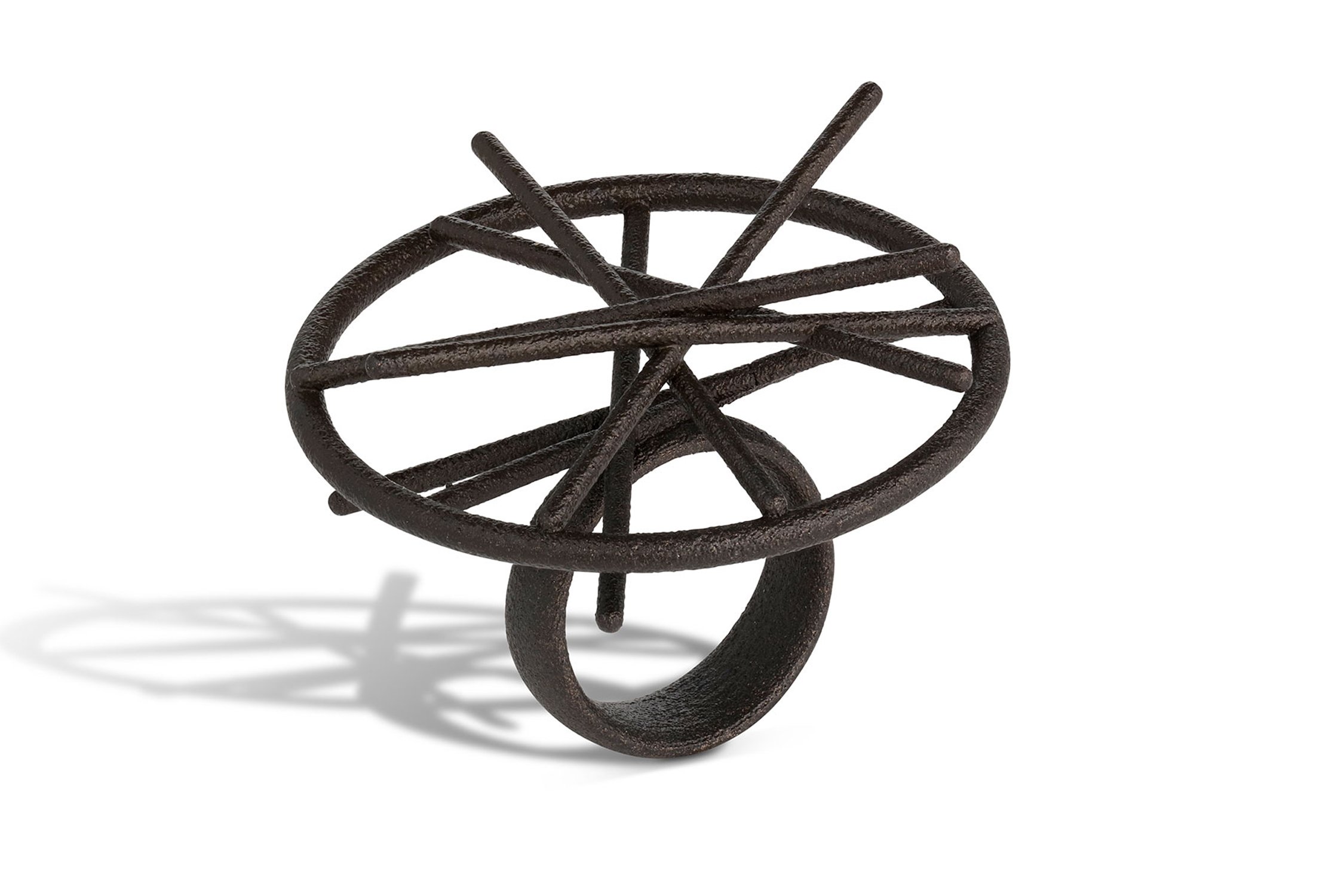 A small, dark, metal sculpture resembling a bird or abstract creature with a circular body, thin legs, and elongated parts on top, casting a shadow on a white background.
