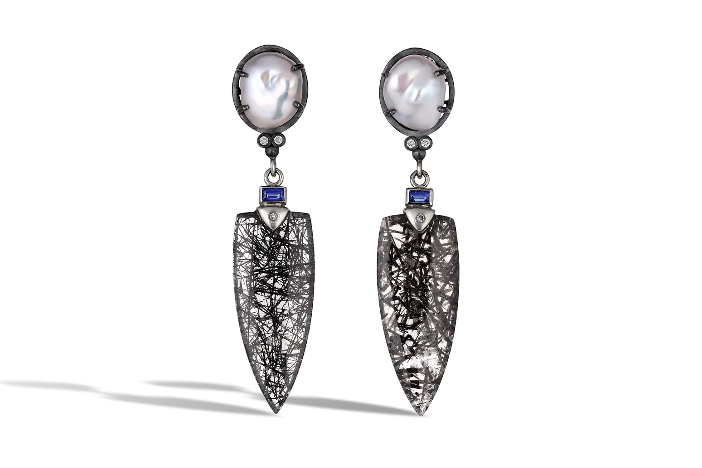 Pair of earrings with large pearl tops and black textured pendant dangles.