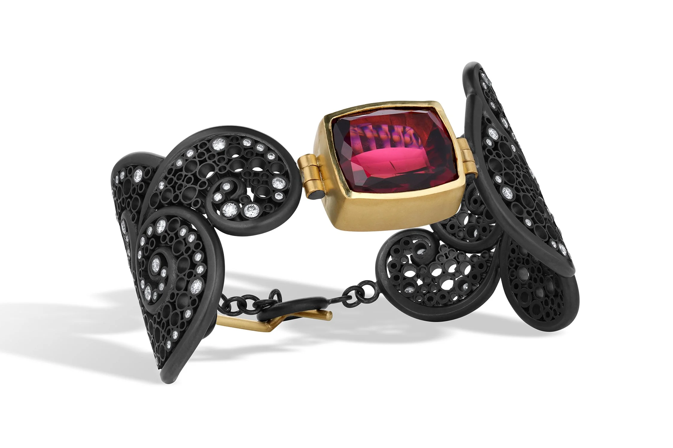 A black fashion bracelet with open circles and embedded rhinestones, featuring a large red gemstone with a gold setting, designed to resemble a ladybug.