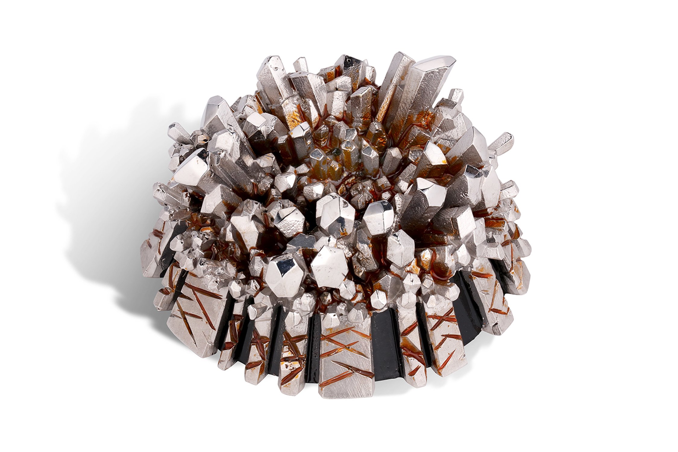 A metallic geometric sculpture with a spiky, rounded shape against a white background.