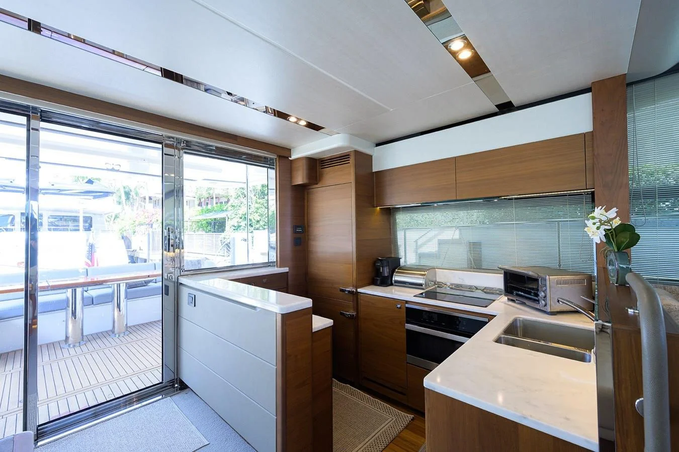Galley kitchen and interior living space aboard Paulasea, a privately owned Princess 68 Flybridge yacht available for charter in Palm Beach, Florida.