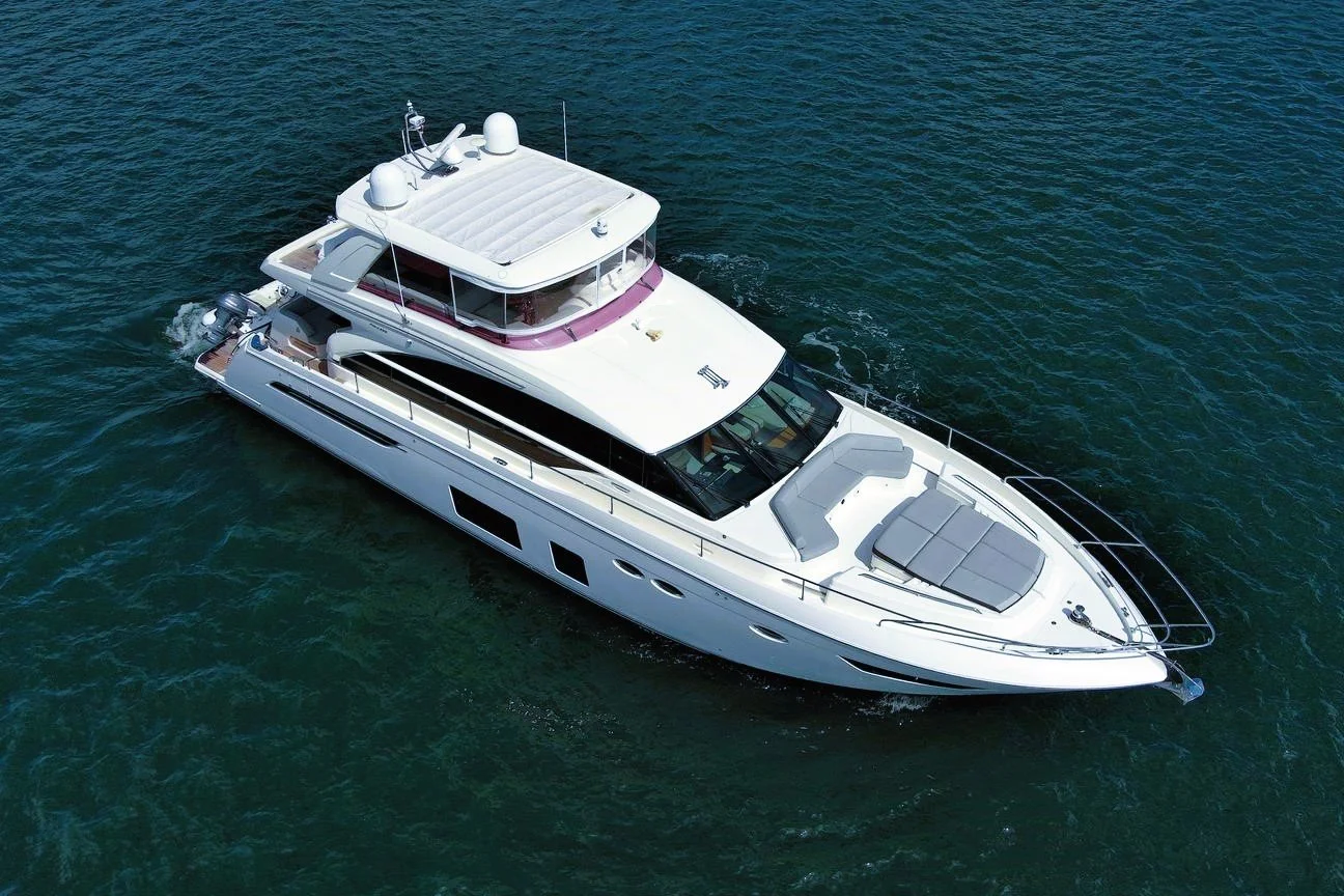 An aerial view of a white luxury yacht cruising in the water.
