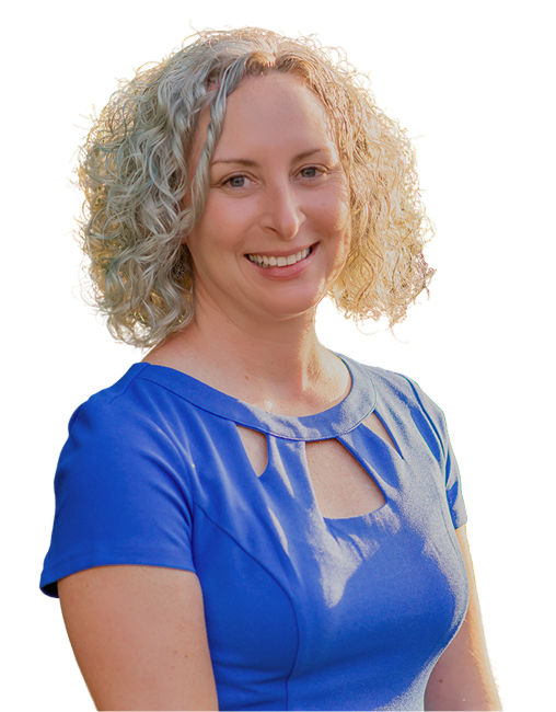 A woman with curly blonde hair smiling, wearing a blue dress with cut-out details on the shoulders, against a plain background.