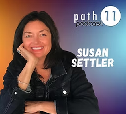 A woman with shoulder-length dark hair smiling, wearing a black denim jacket, sitting with her left hand supporting her face. The background features a gradient of orange, purple, and blue. Text on the image reads 'Path 11 Podcast' and 'Susan Settler'.