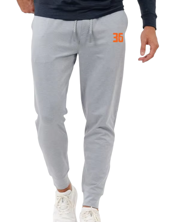 Person wearing light gray sweatpants with the number 36 in orange on the upper right thigh, and white sneakers.