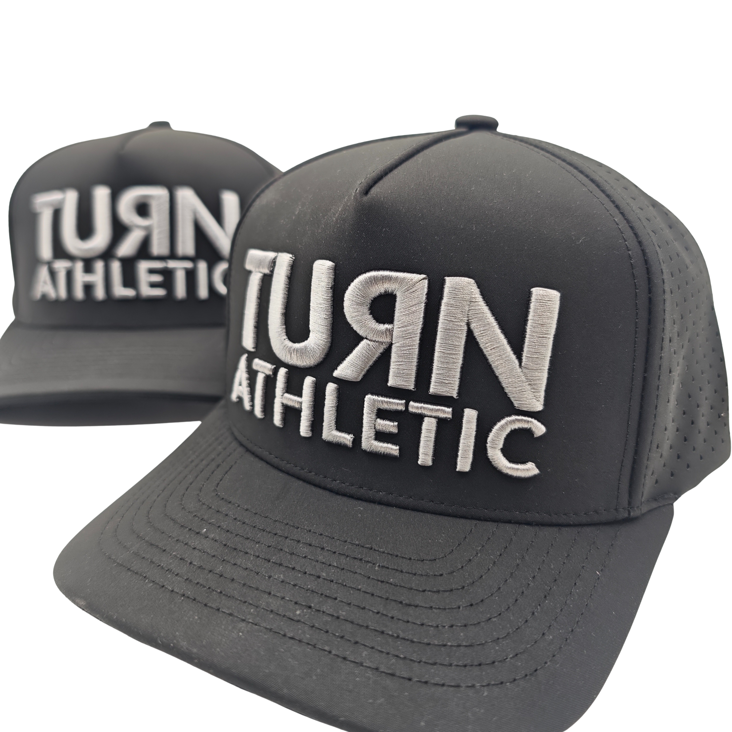 Two black athletic caps with gray embroidered text reading "NUR ATHLETIC," with one cap positioned in front of the other.