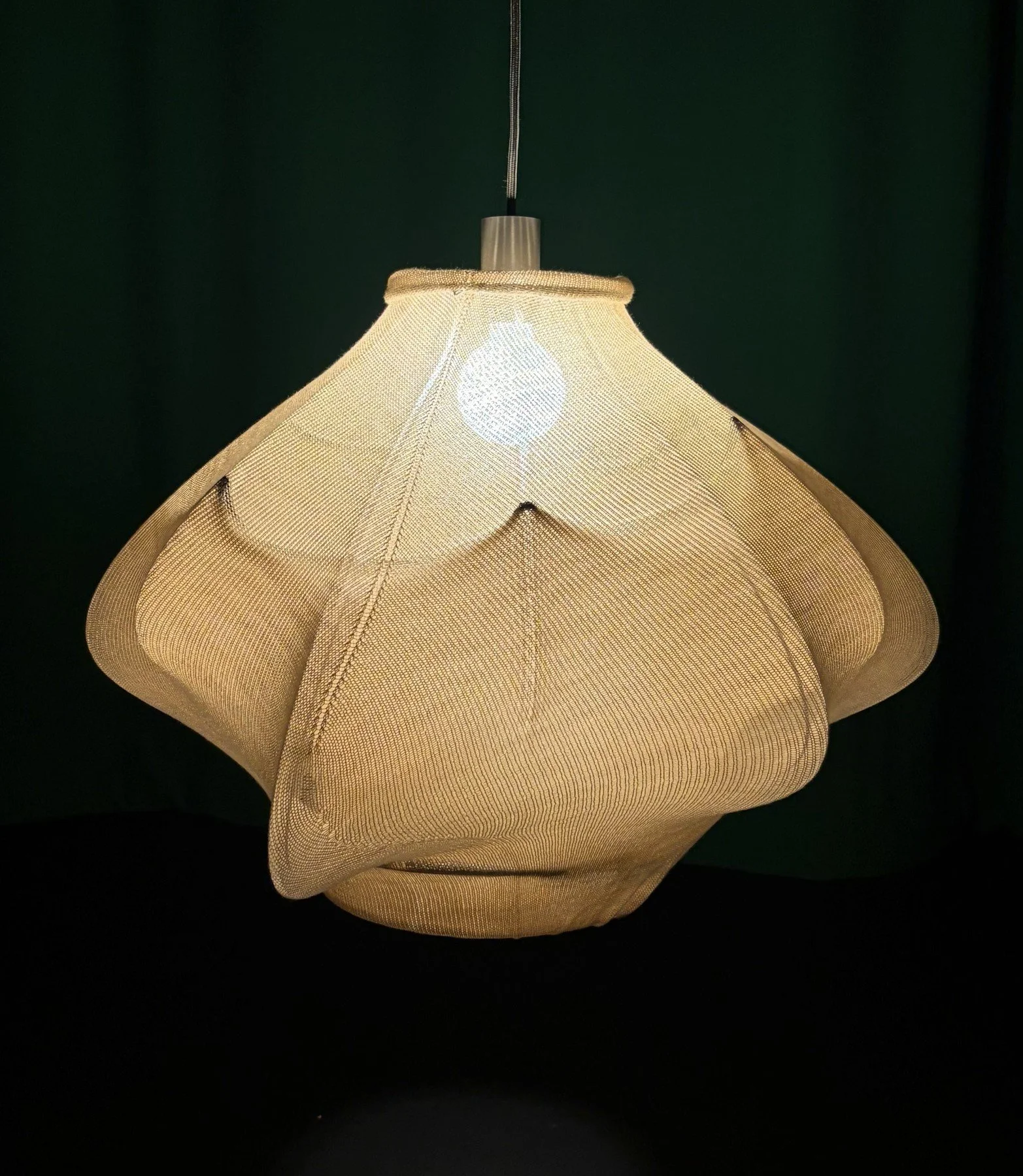 Fuzz Cloud knitted pendant illuminated against a dark background