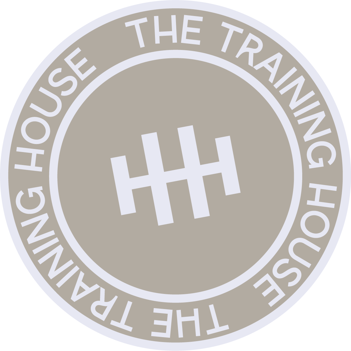 A circular logo with a gray background, featuring the words "THE TRAINING HOUSE" around the edge, and a white symbol in the center resembling a stylized letter H with an additional small horizontal line.