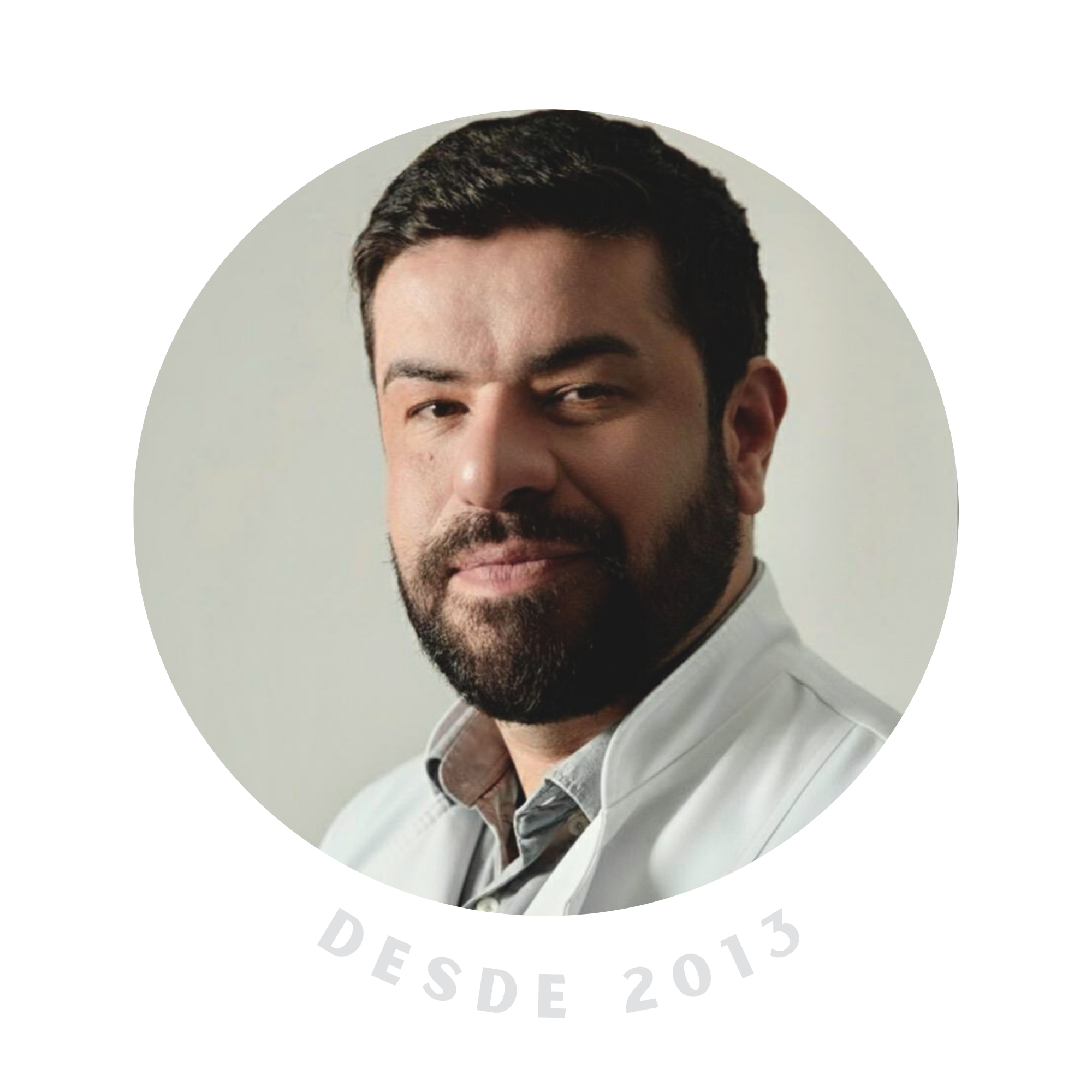 Homem com barba e cabelo escuro, vestindo jaleco branco, fotografado de frente com expressão confiante